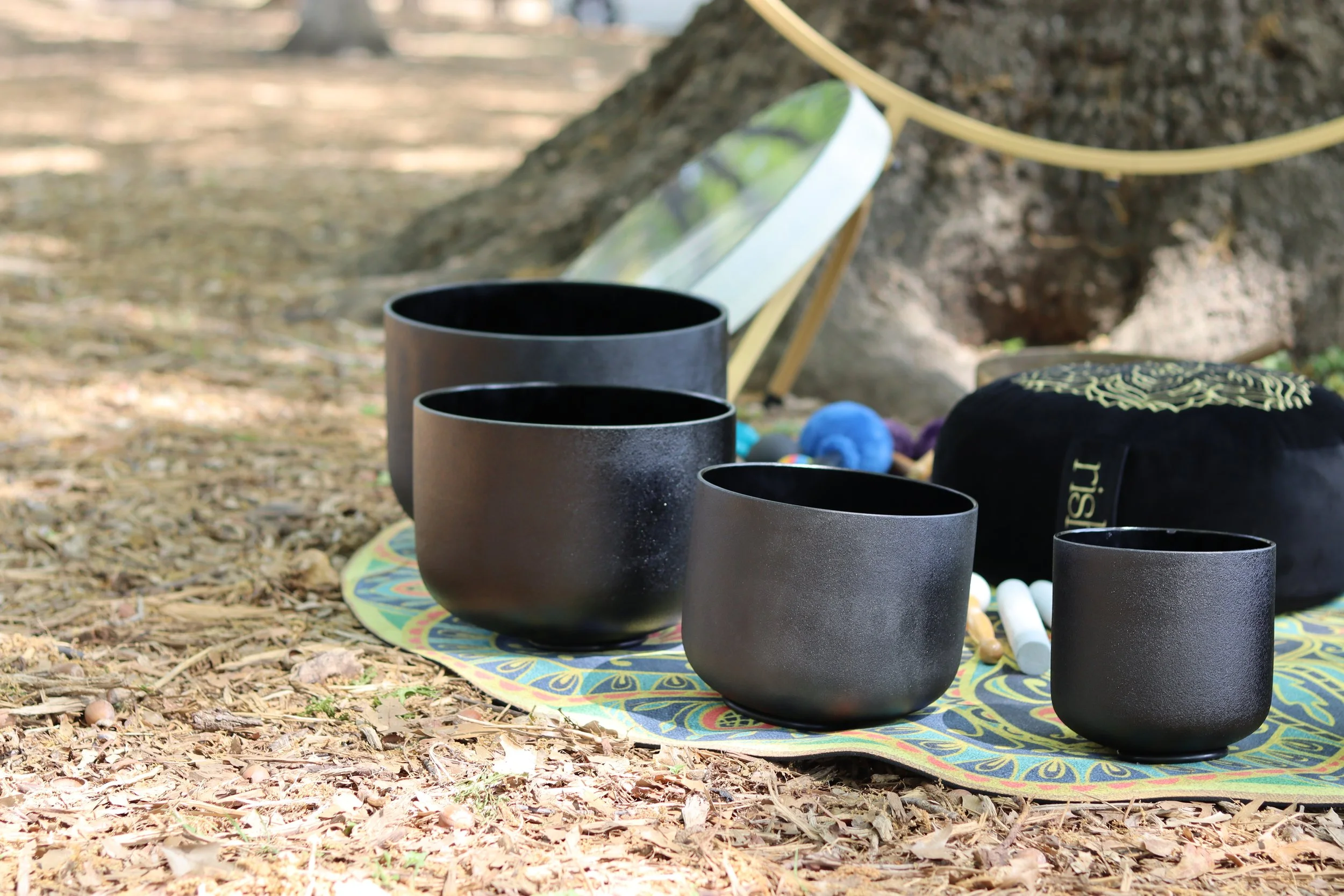 Black crystal singing bowls used for meditation, sound baths, and nervous system relaxation