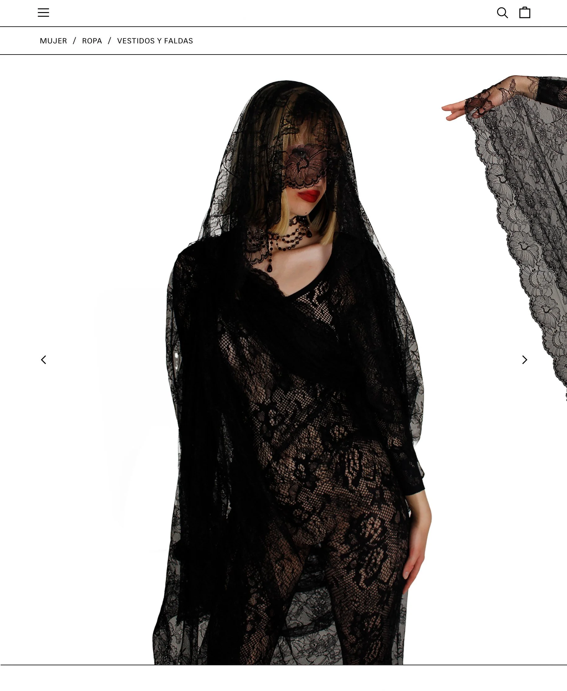 Mujer con vestido y capa de encaje negro, con collar y pendientes negros, con cabello rubio y labios rojos, cubriéndose parcialmente la cara con un velo de encaje negro.