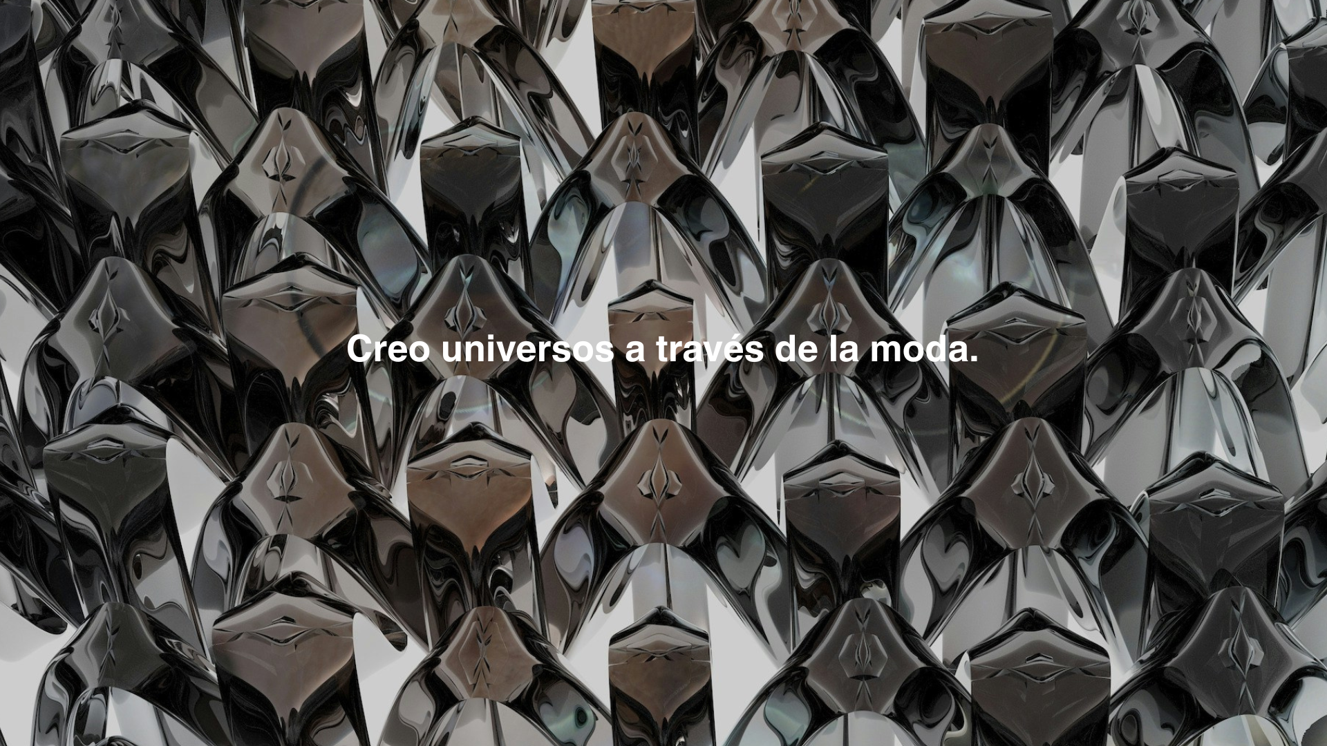 superficie reflectante con un patrón de formas abstractas de color negro y gris y frase en español 'Creo universos a través de la moda'.