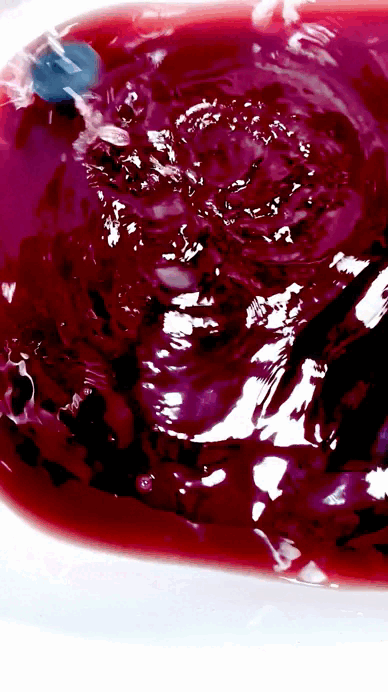 Vaso con jugo de uva morada y hielo.