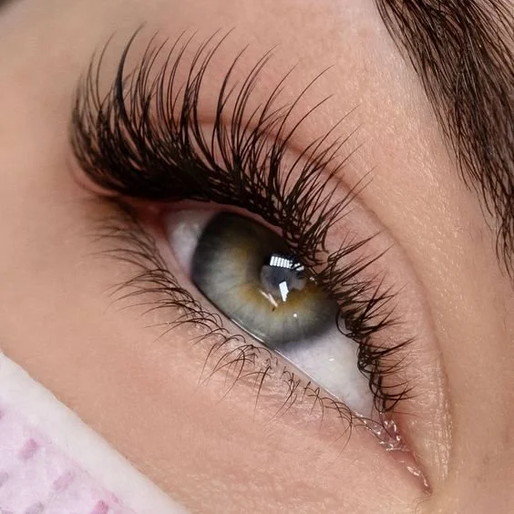 Close-up of a human eye with long eyelashes and hazel eye color.