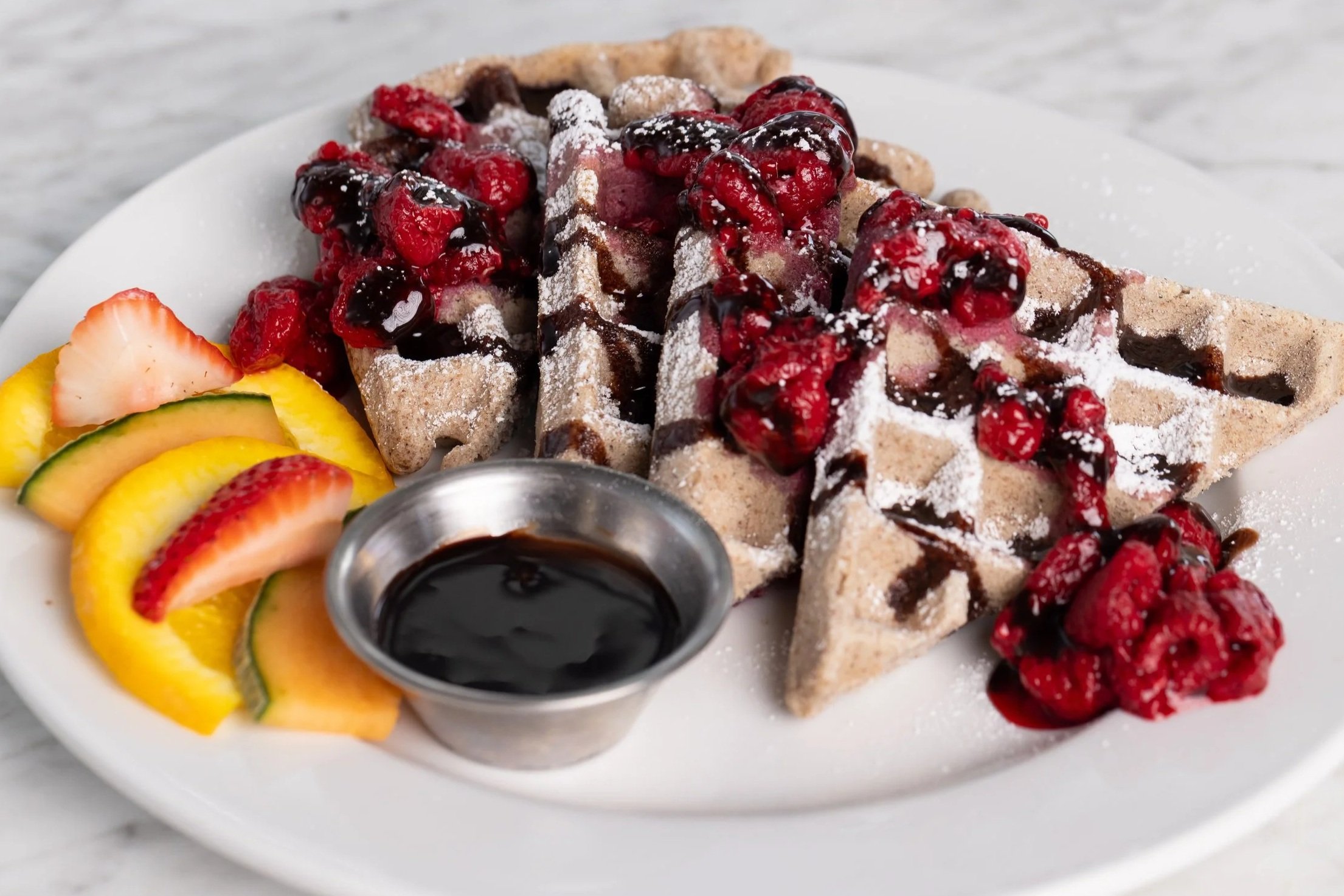 Waffles with raspberries, powdered sugar and chocolate syrup At Fancy Pants Cafe in Bridgewater, Nova Scotia