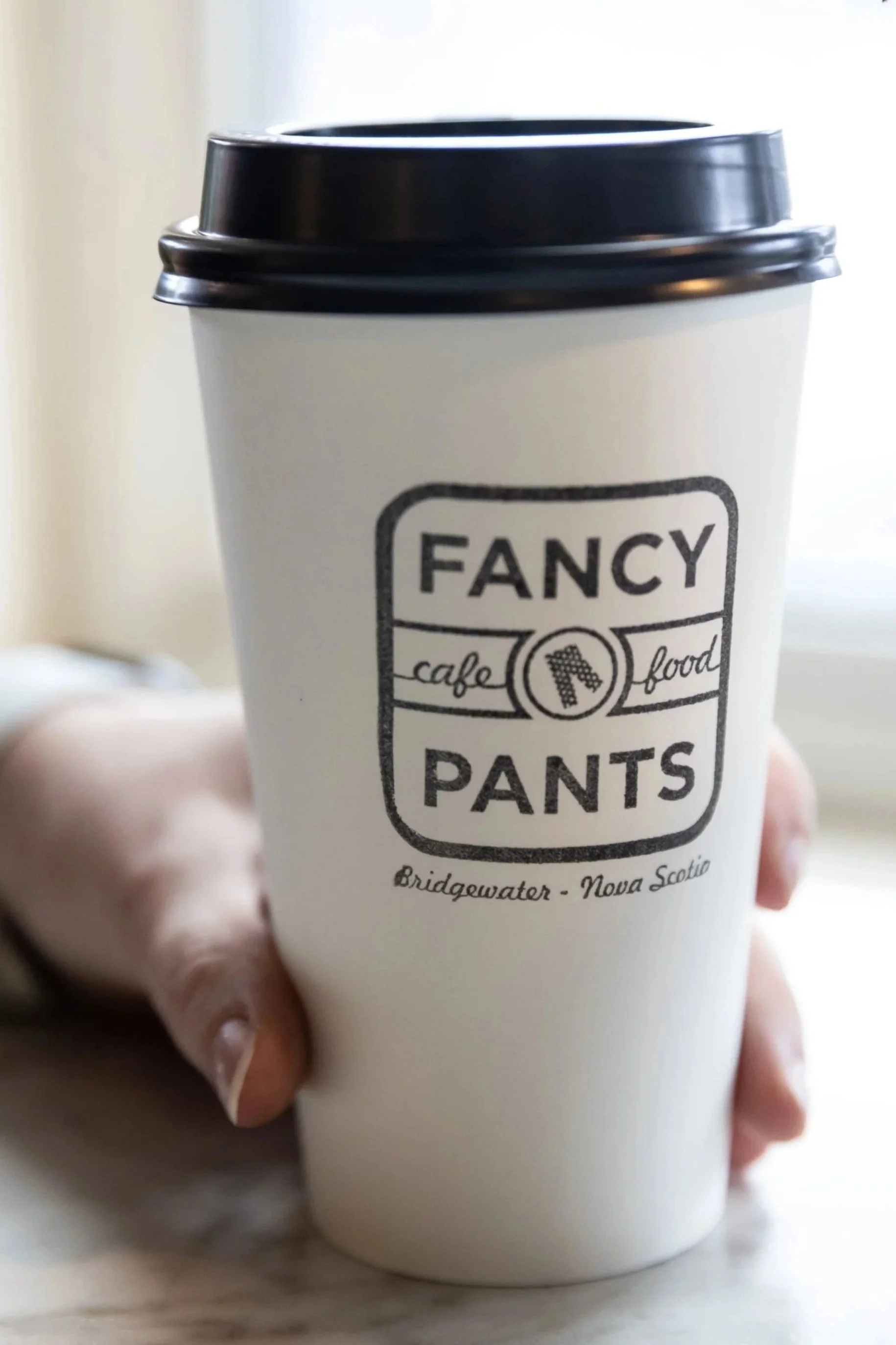 Close up of Fancy Pants branded to-go coffee cup At Fancy Pants Cafe in Bridgewater, Nova Scotia