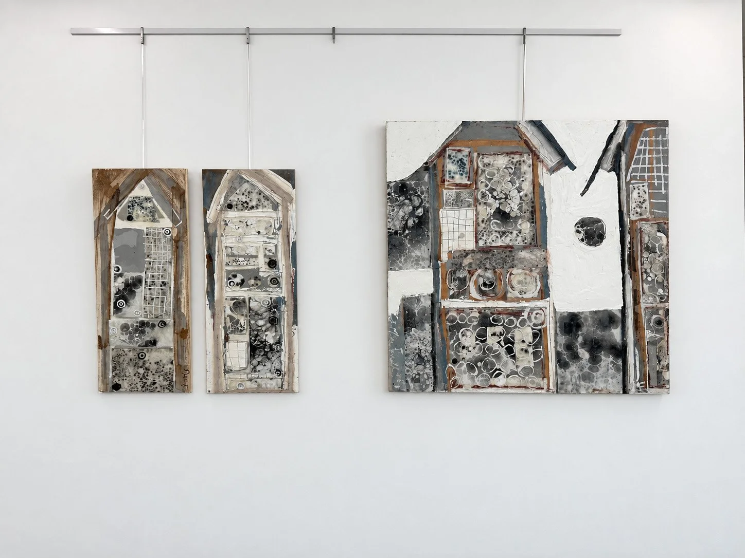 Three Insect Hotels paintings by Erin McGee Ferrell installed on a white gallery wall.