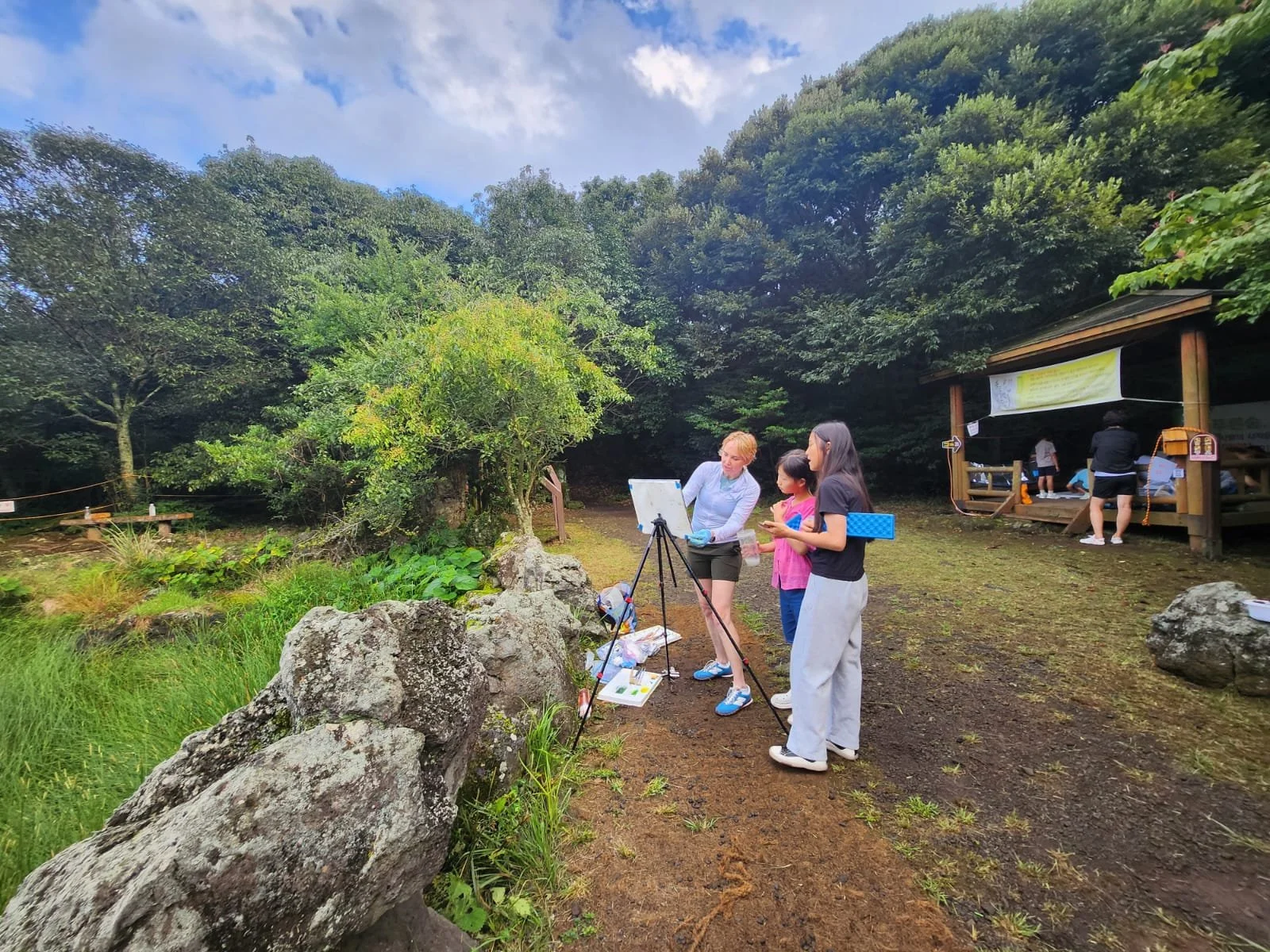 Erin McGee Ferrell demonstrating plein air painting with local schoolchildren at Dongbaekdongsan, Jeju Island, during Jeju Art for Earth 2025.