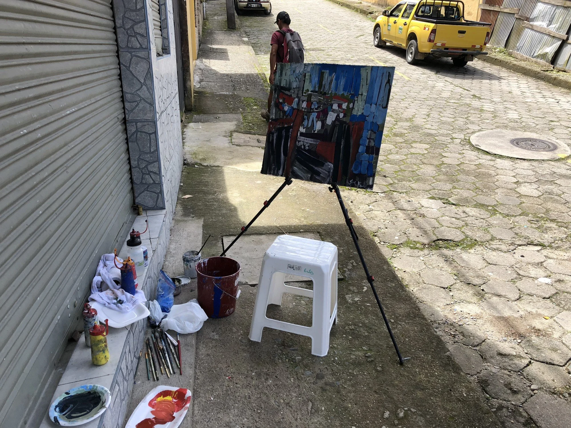 Erin McGee Ferrell’s plein air painting setup on a Tena street, with a painting, brushes, and locally sourced supplies.