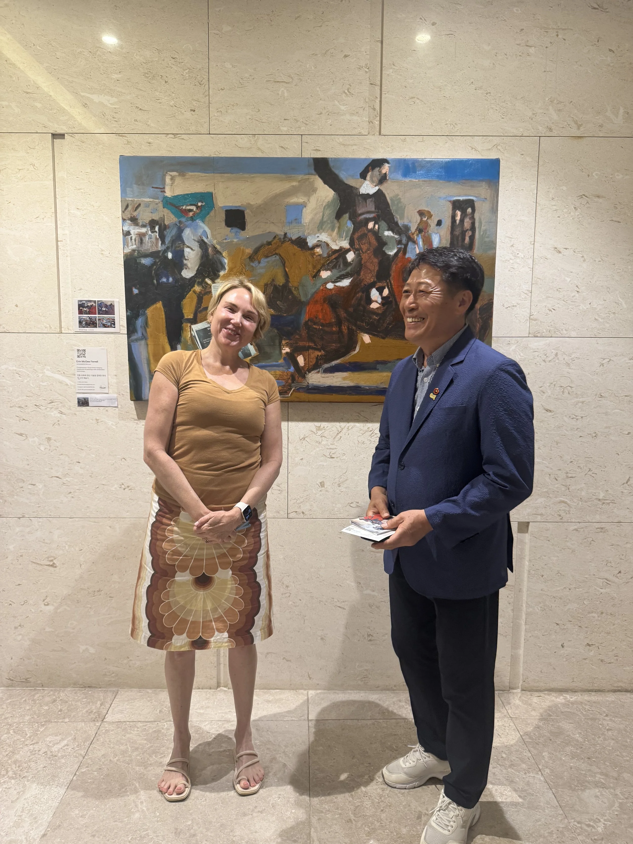 Erin McGee Ferrell discussing her painting Bird, Girl, and Horse with an exhibition visitor at Jeju Art for Earth, Jeju Island, September 2025.
