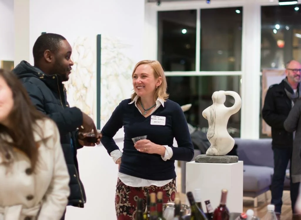 Erin McGee Ferrell in conversation at a gallery gathering.