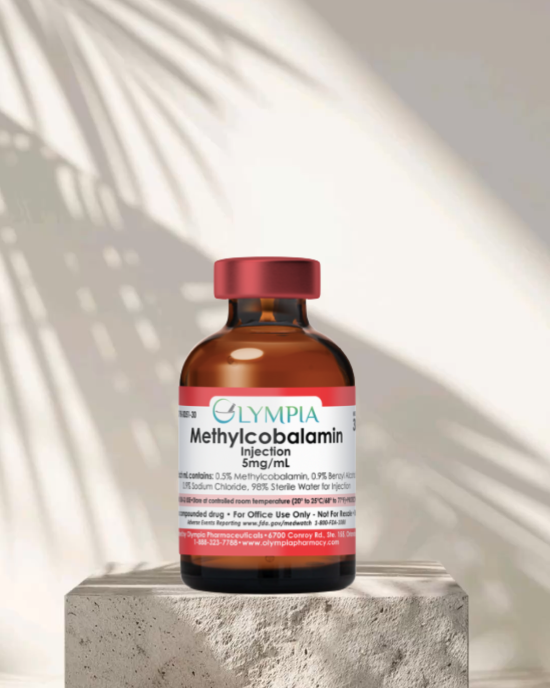 A medicine bottle labeled Olympa Methylcobalamin Injection 5mg/mL on a concrete surface with shadow and light pattern on the wall behind.