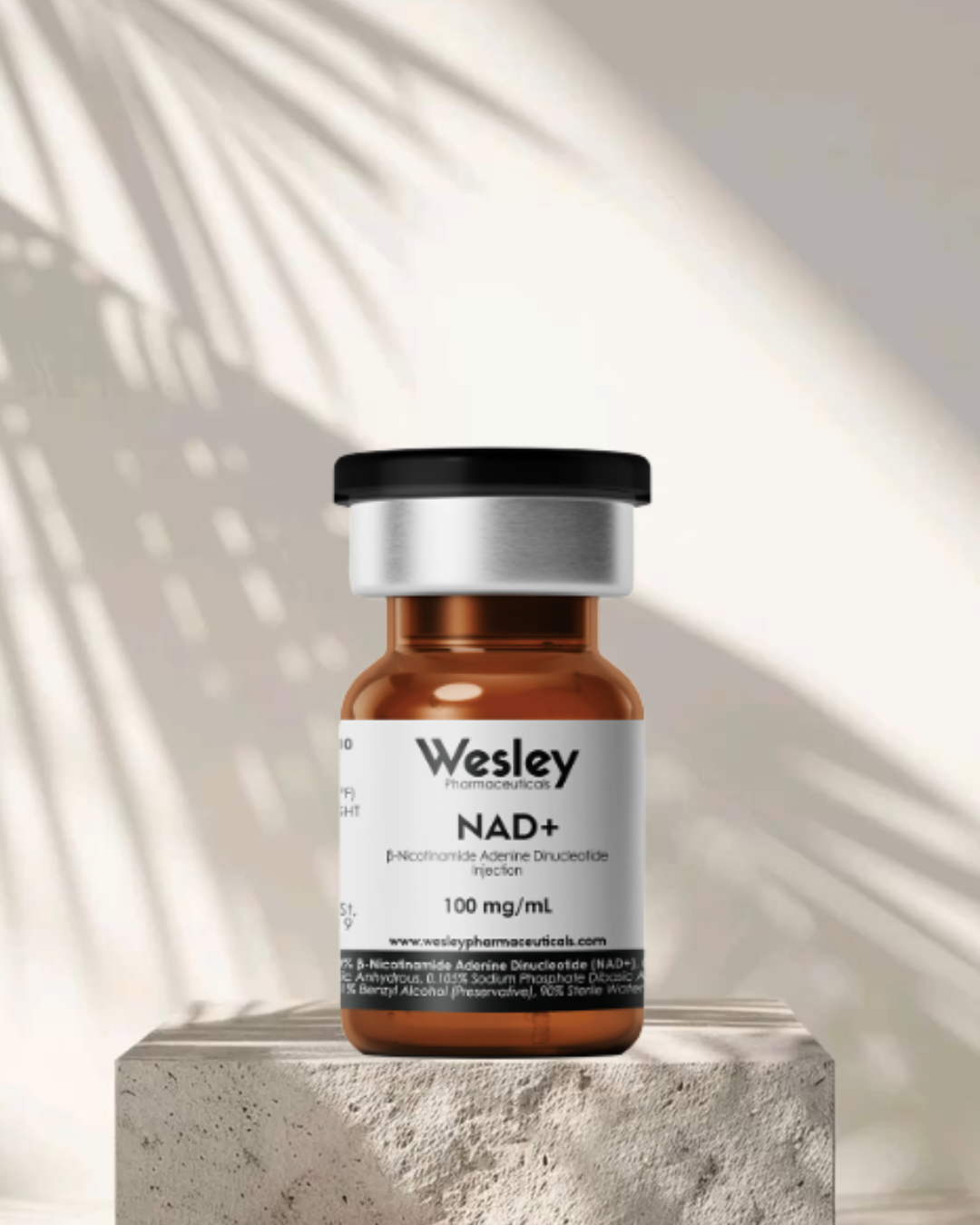 A brown glass vial labeled 'Wesley Pharmaceuticals NAD+ 100 mg/mL' with a black cap, placed on a textured surface with soft shadows and light patterns in the background.