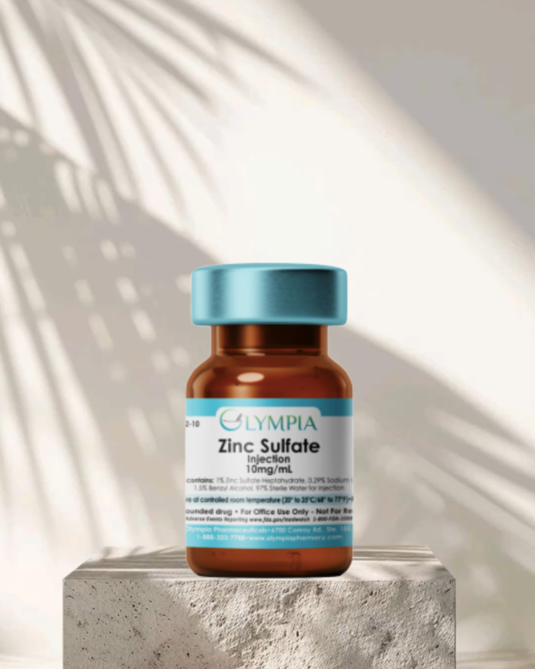 A bottle of Zinc Sulfate injection on a concrete block with a sunlit background and shadow of palm leaves.