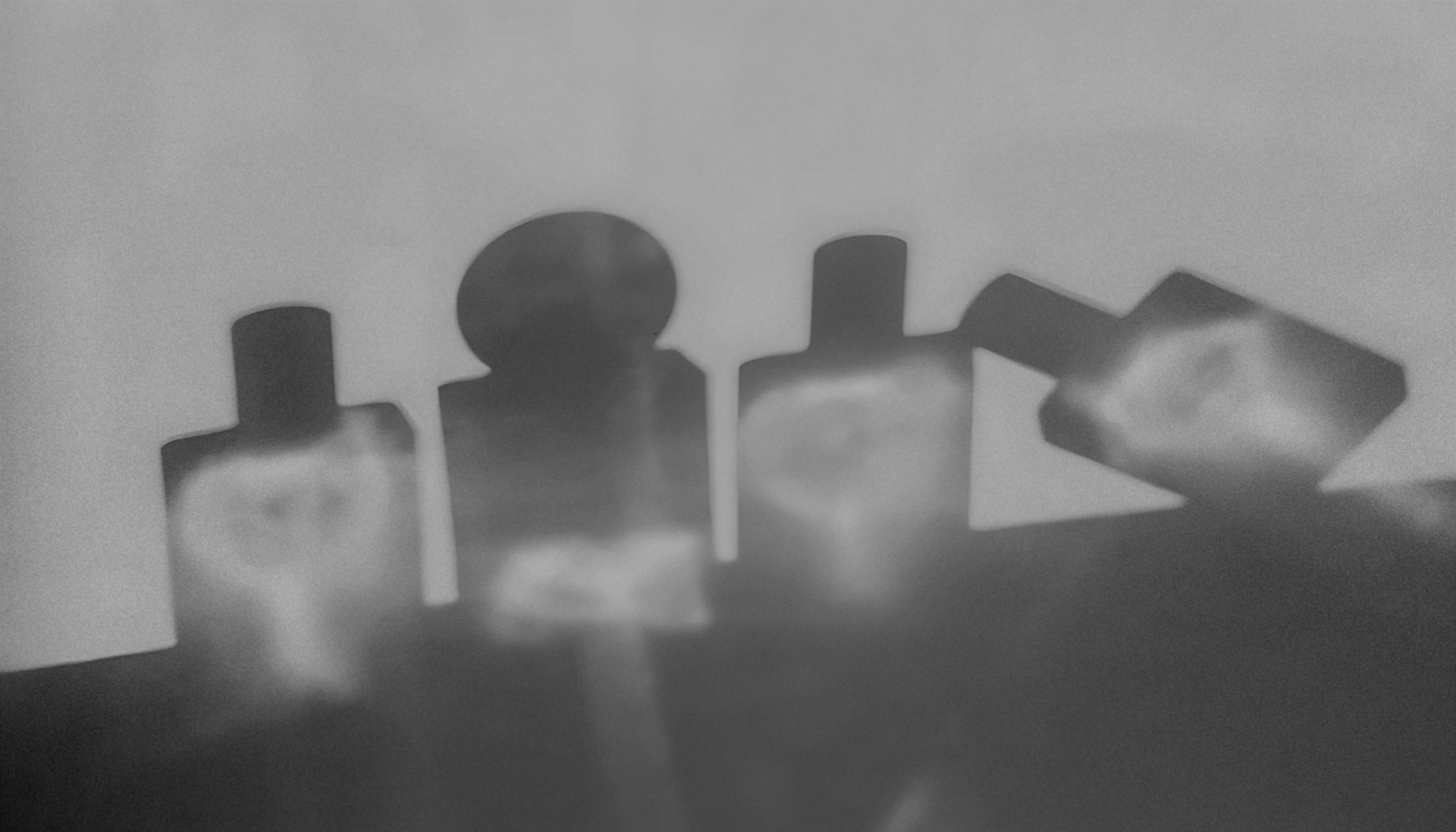 Close-up of scattered pill tablets on a flat surface, some overlapping, with a blurred background.