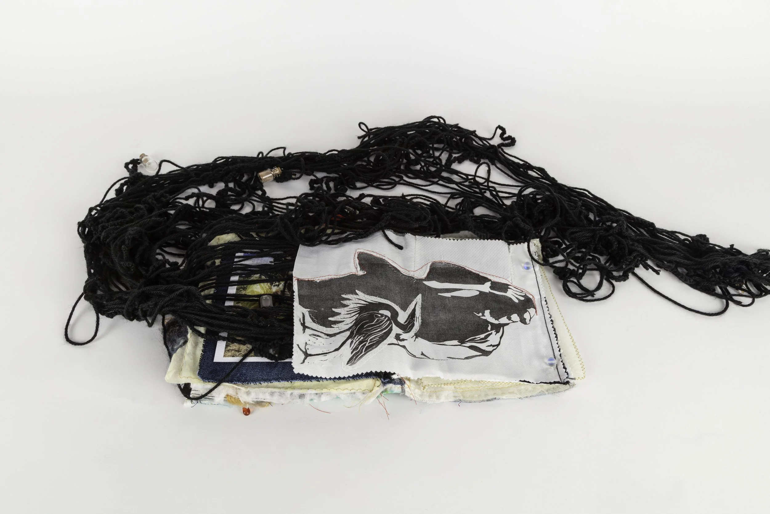 Father silhouette and Heron Lino print attached with hand stitch work and crochet tendrils of yarn with attachments of sensory scents