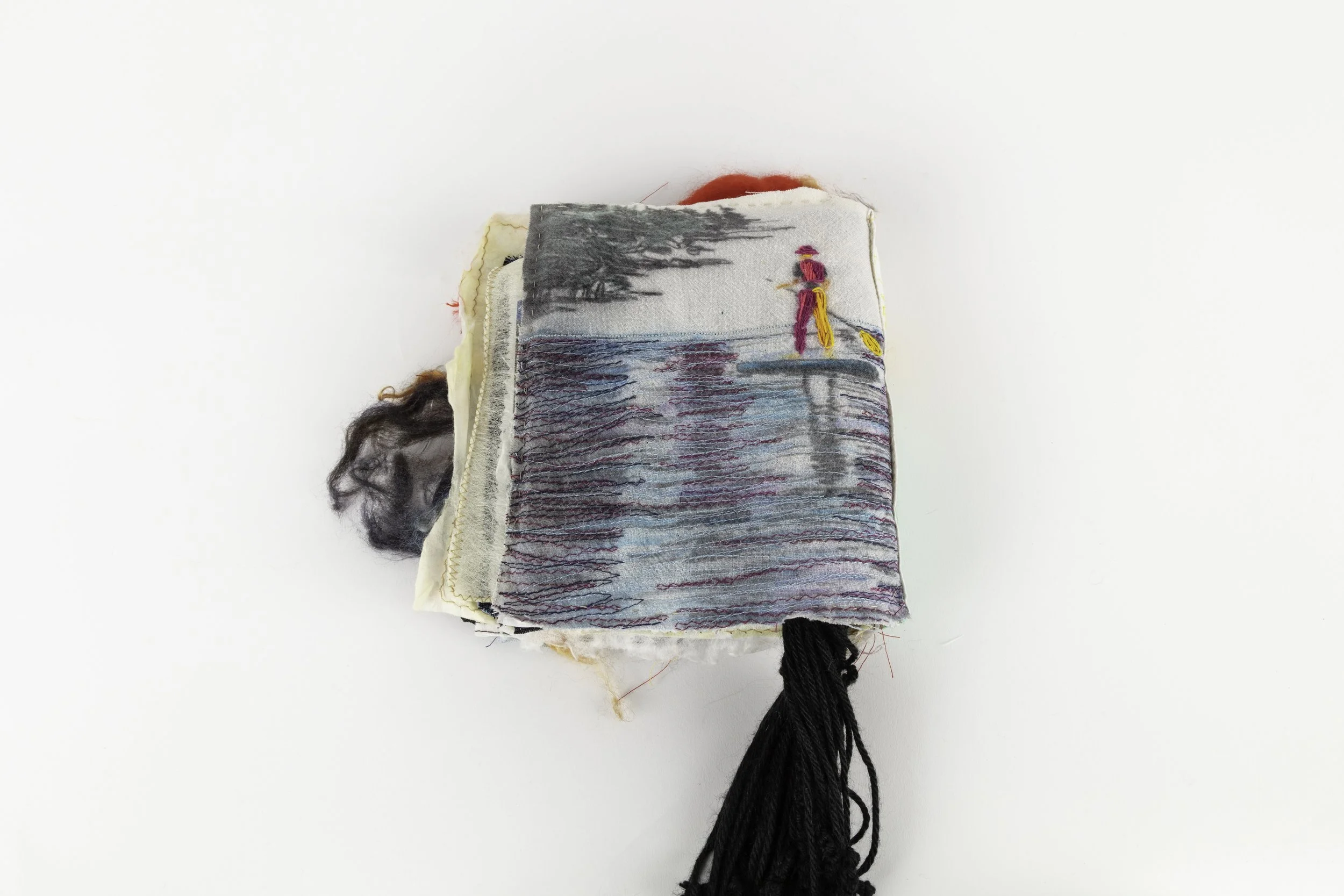 Mono-print with top stitch work of a human figure paddle boarding on water, back cover of the fabric journal