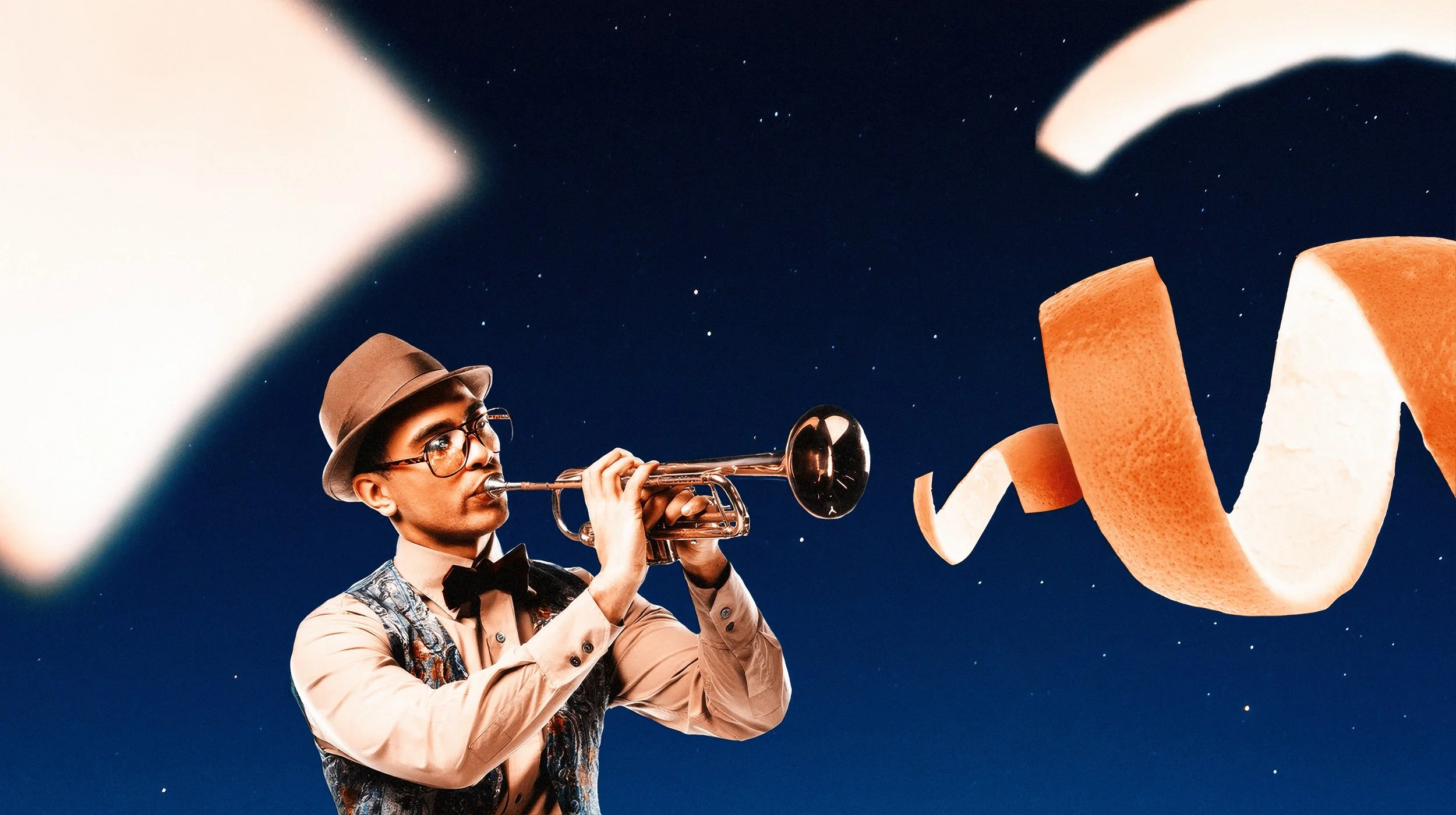 A person dressed in vintage style with a hat and glasses is playing a trumpet against a starry night sky. There are large wood shavings floating around.