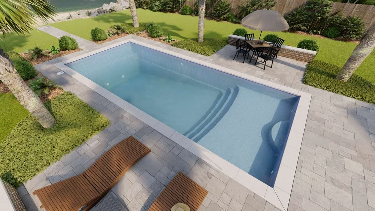 Backyard with a rectangular swimming pool, two wooden lounge chairs, a patio table with four chairs under an umbrella, green lawn, trees, shrubs, and a wooden fence.