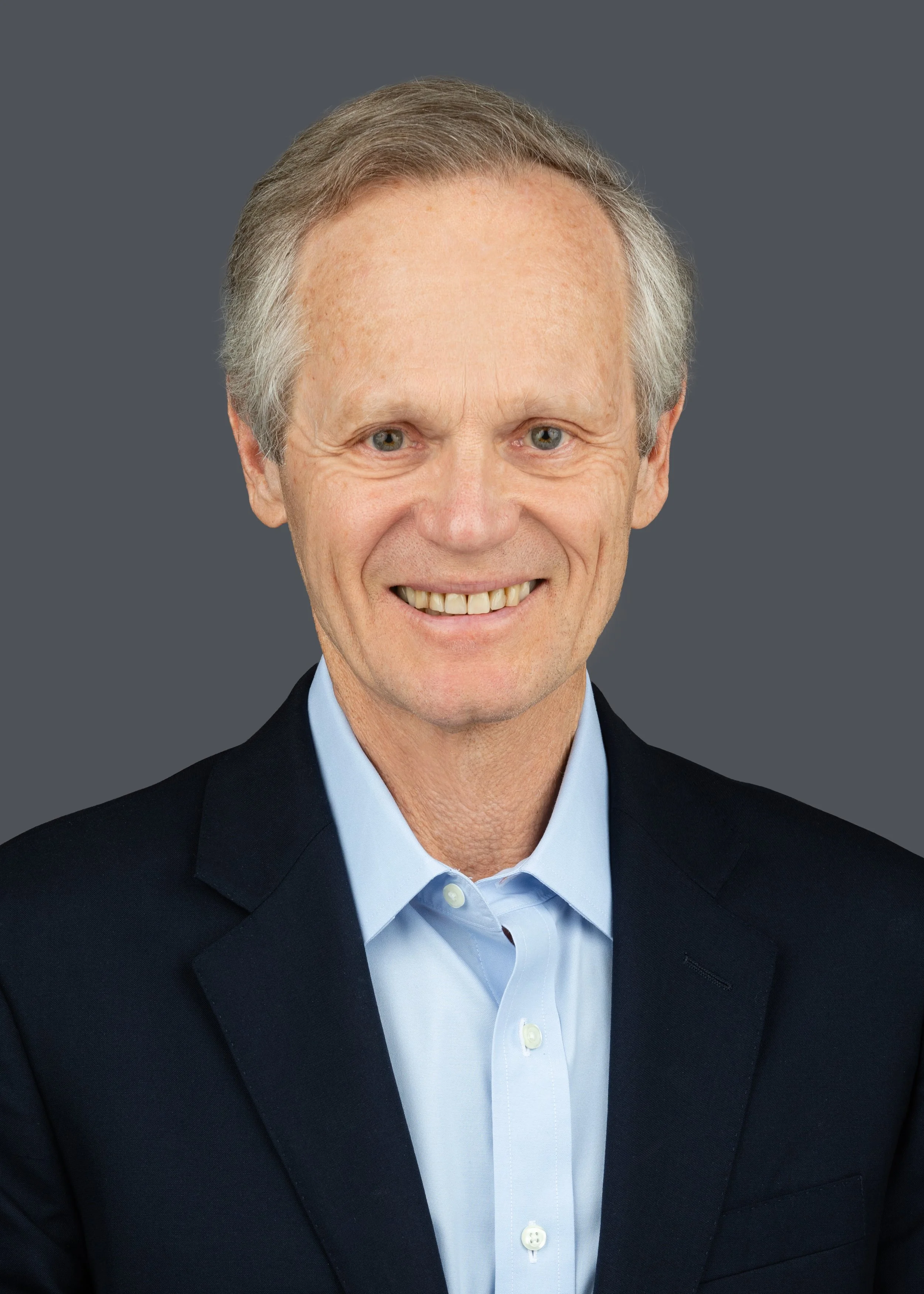 Headshot of author K. W. Franklin smiling into the camera, wearing a light blue shirt and dark suit coat