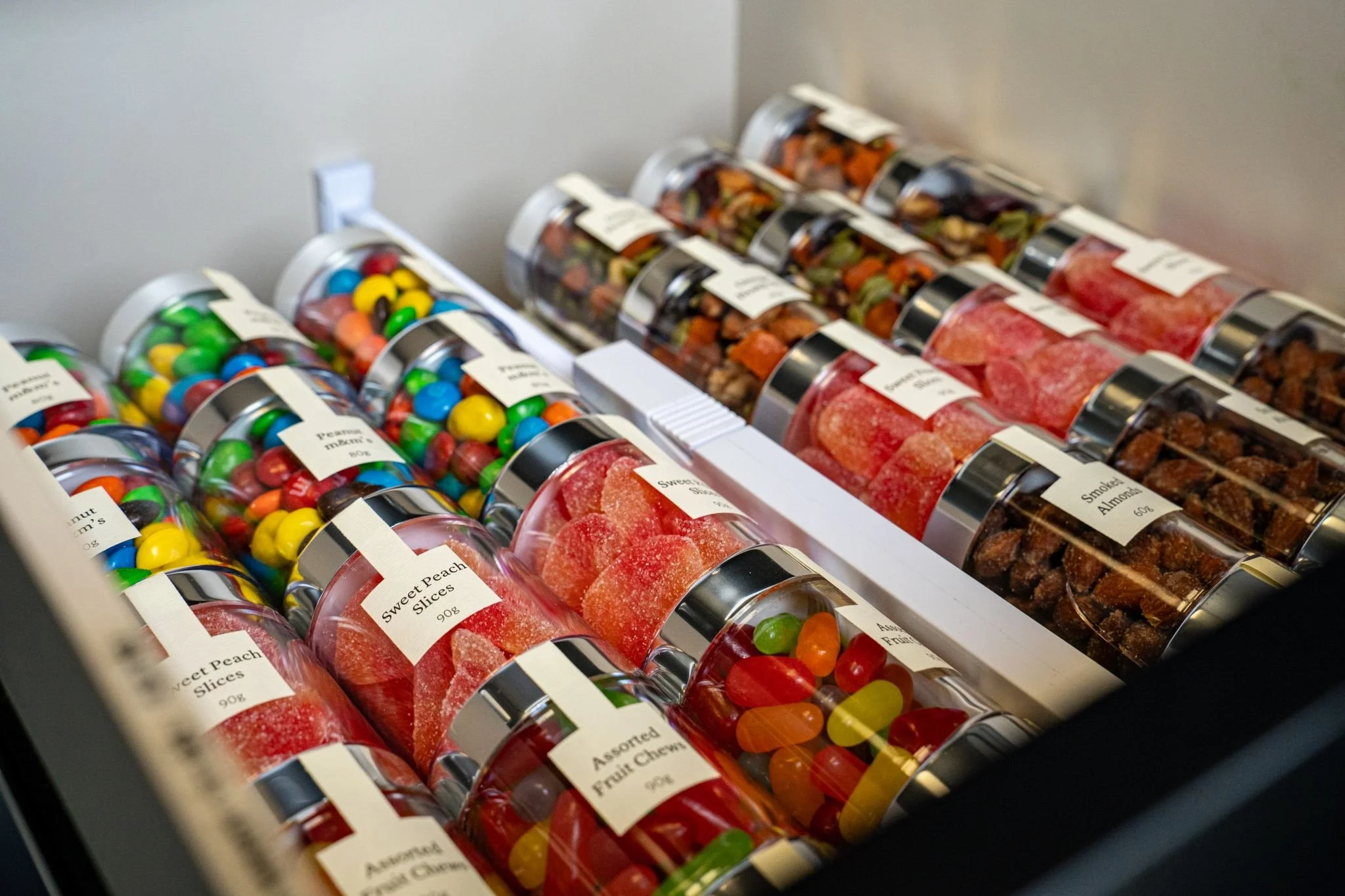 Assorted jars of fruit chews and candies lined up in a box.