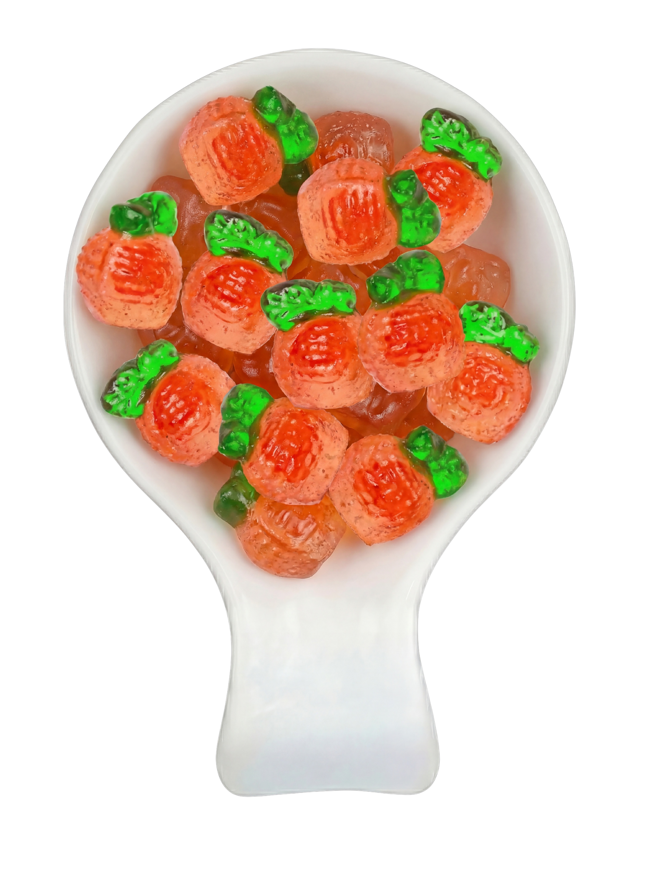 Candy shaped like carrots with orange and green colors, arranged in a white spoon against a black background.