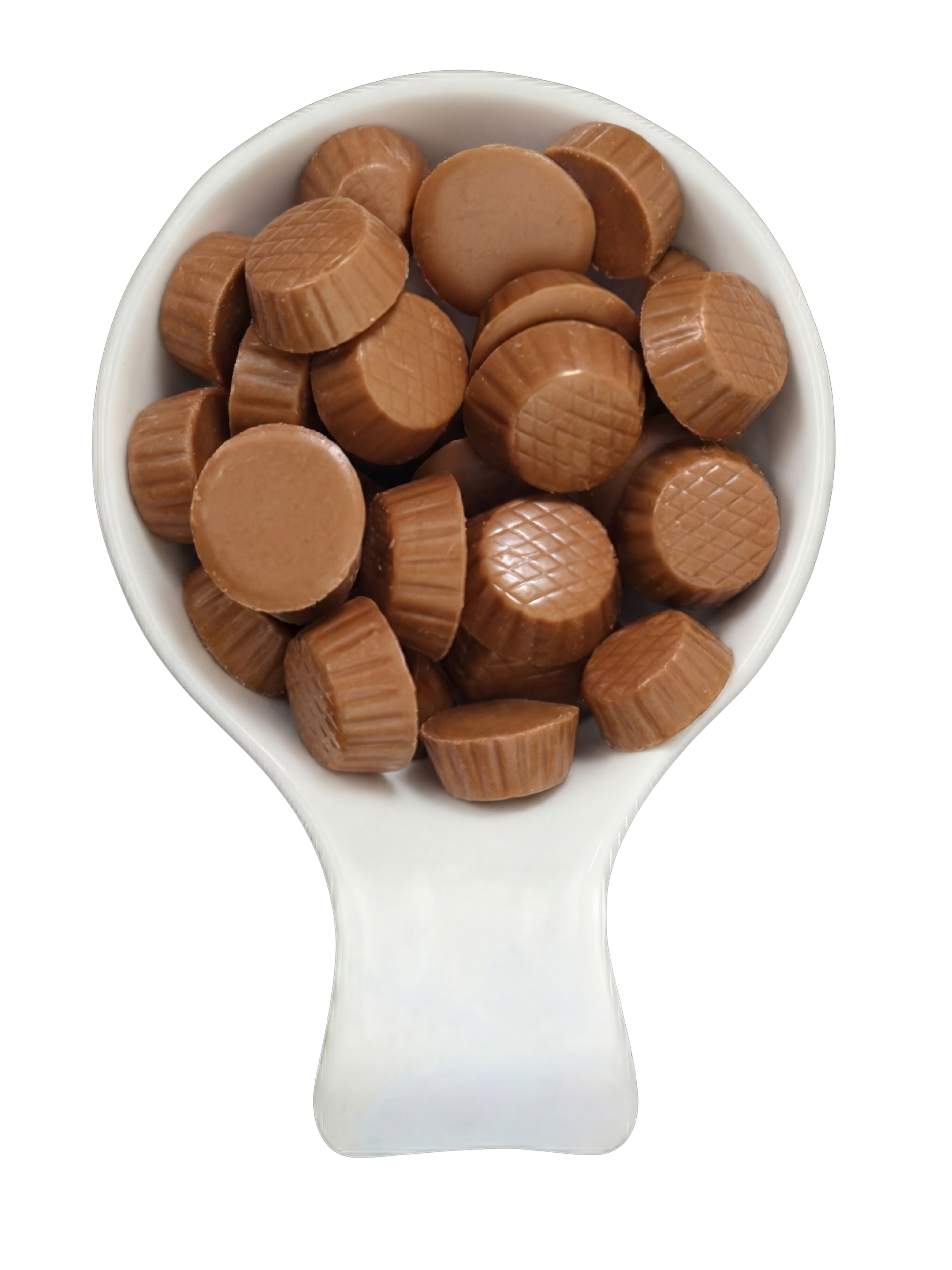 A white ceramic spoon filled with small, round, light brown milk chocolates with a textured pattern on top, placed against a black background.