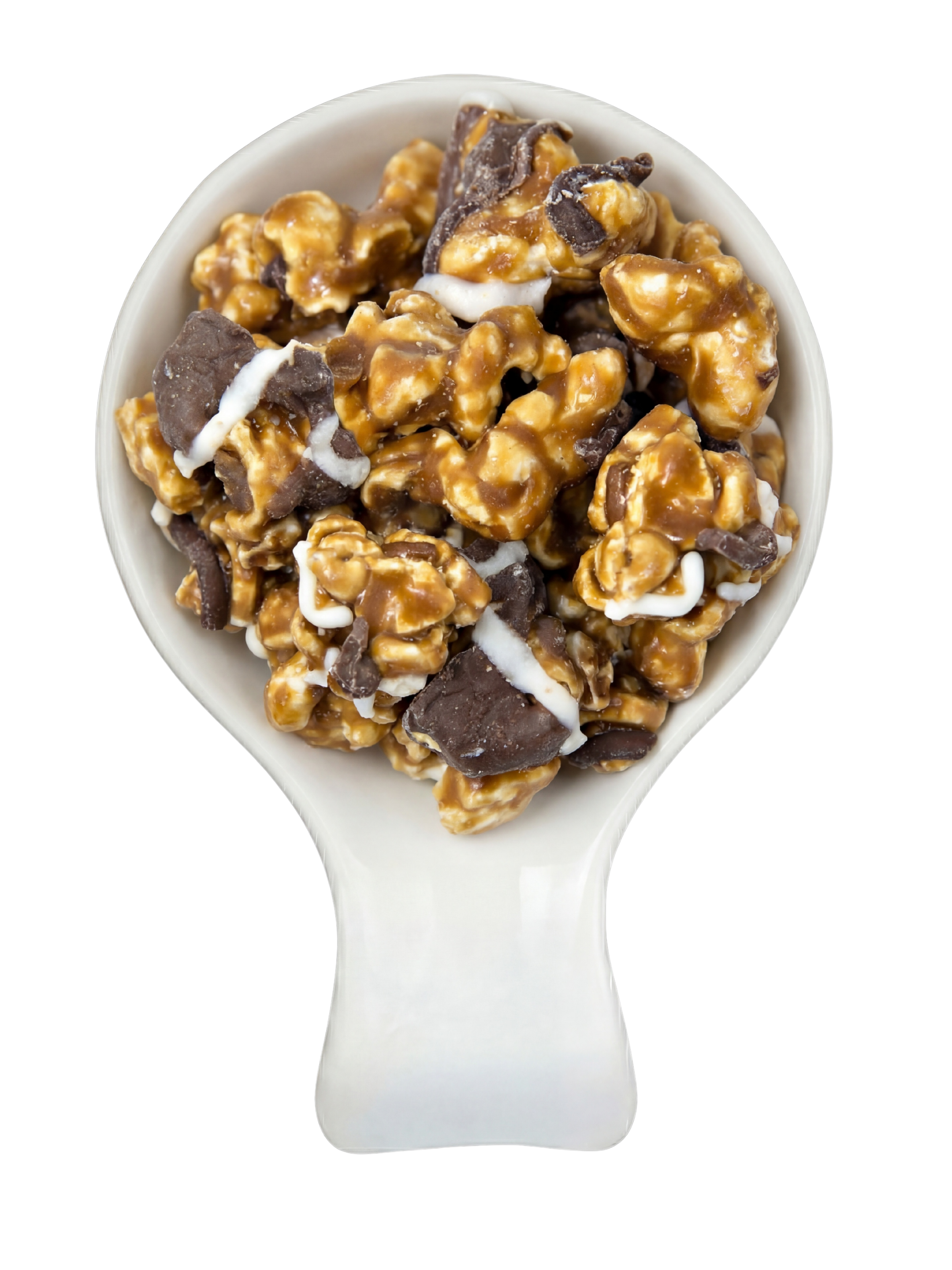 A white spoon filled with caramel popcorn, chocolate chunks, and white drizzle, with a black background.