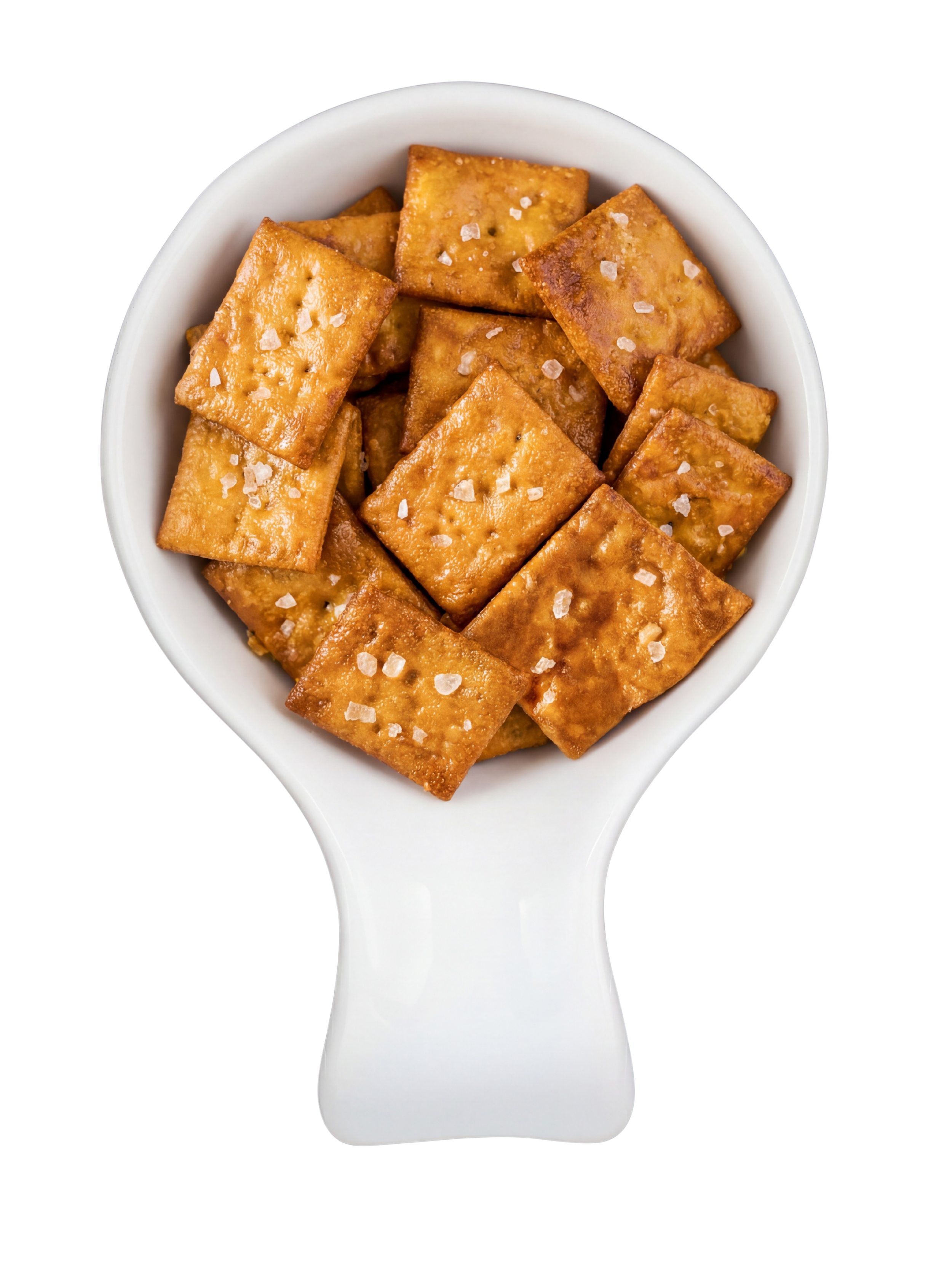 A white spoon filled with salted crackers against a black and red background.