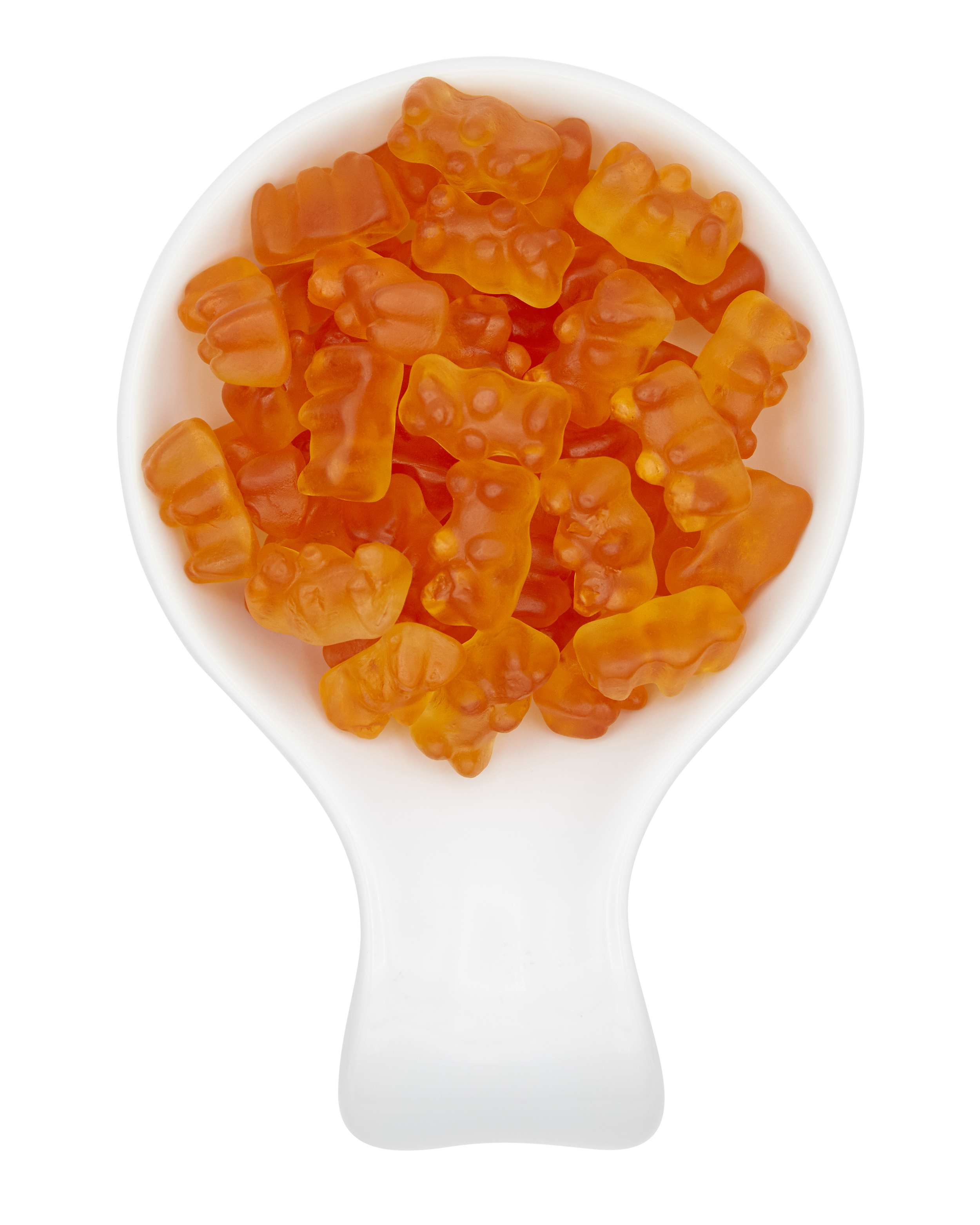Close-up of a white spoon filled with orange gummy bears.
