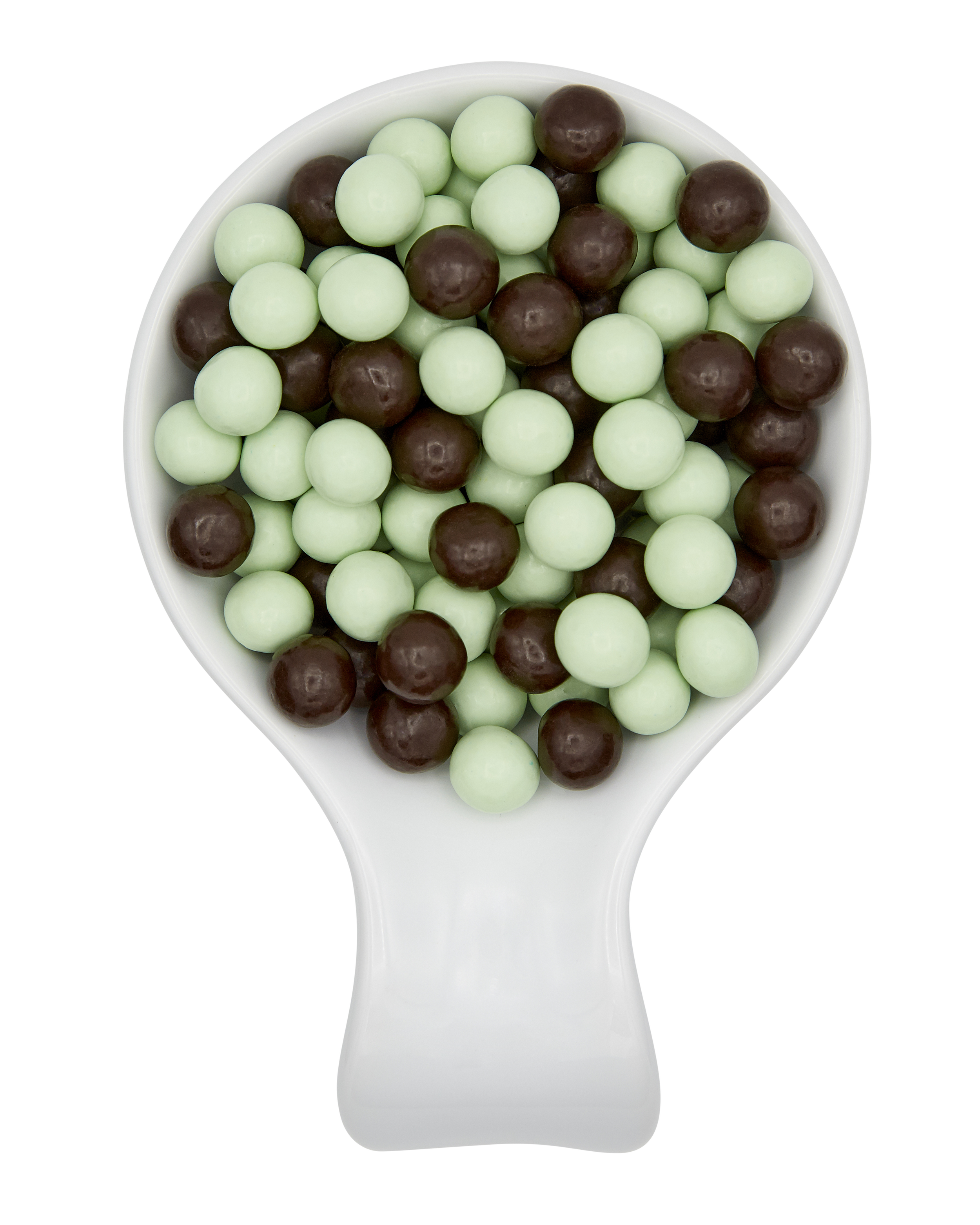 A white scooper filled with green and brown round candies, on a split background with black on the left and gray on the right.
