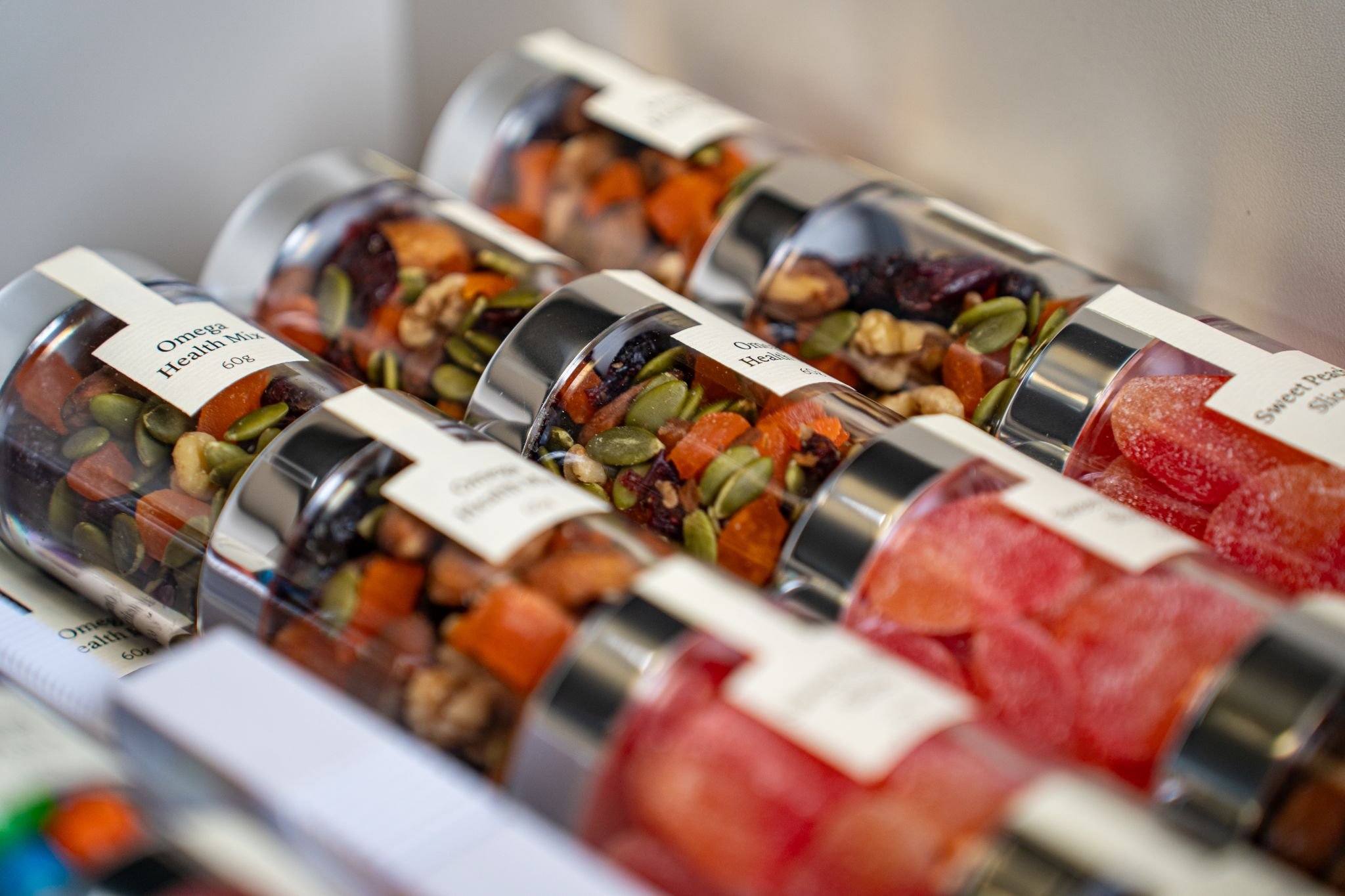Multiple small bottles of mixed trail mix with nuts, seeds, and dried fruits.