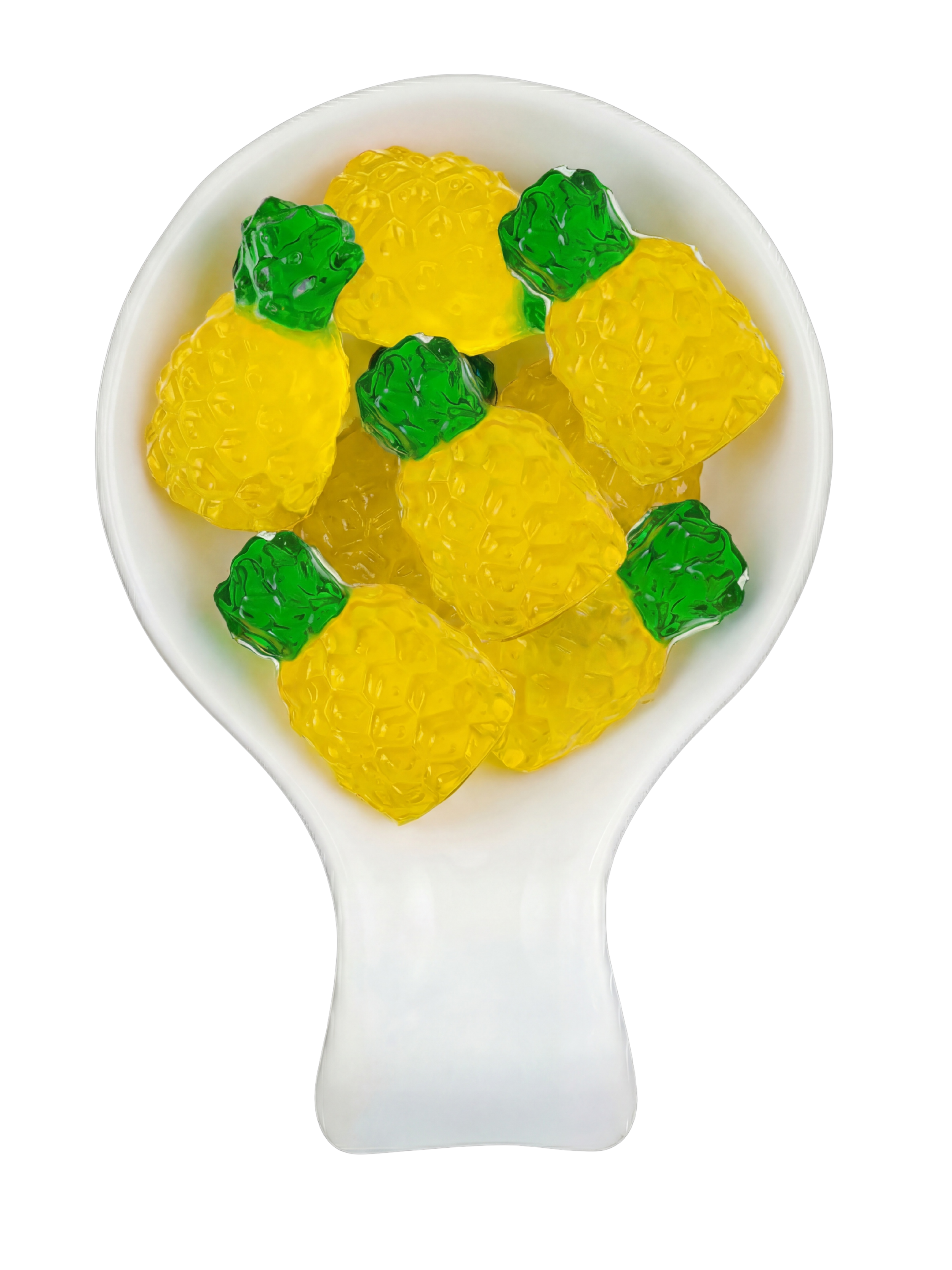 Close-up of a white spoon filled with yellow and green gummy candies shaped like pineapples.