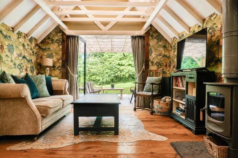 Open-plan living area at The Snuggery featuring a wood-burning stove and views across the Kent countryside.