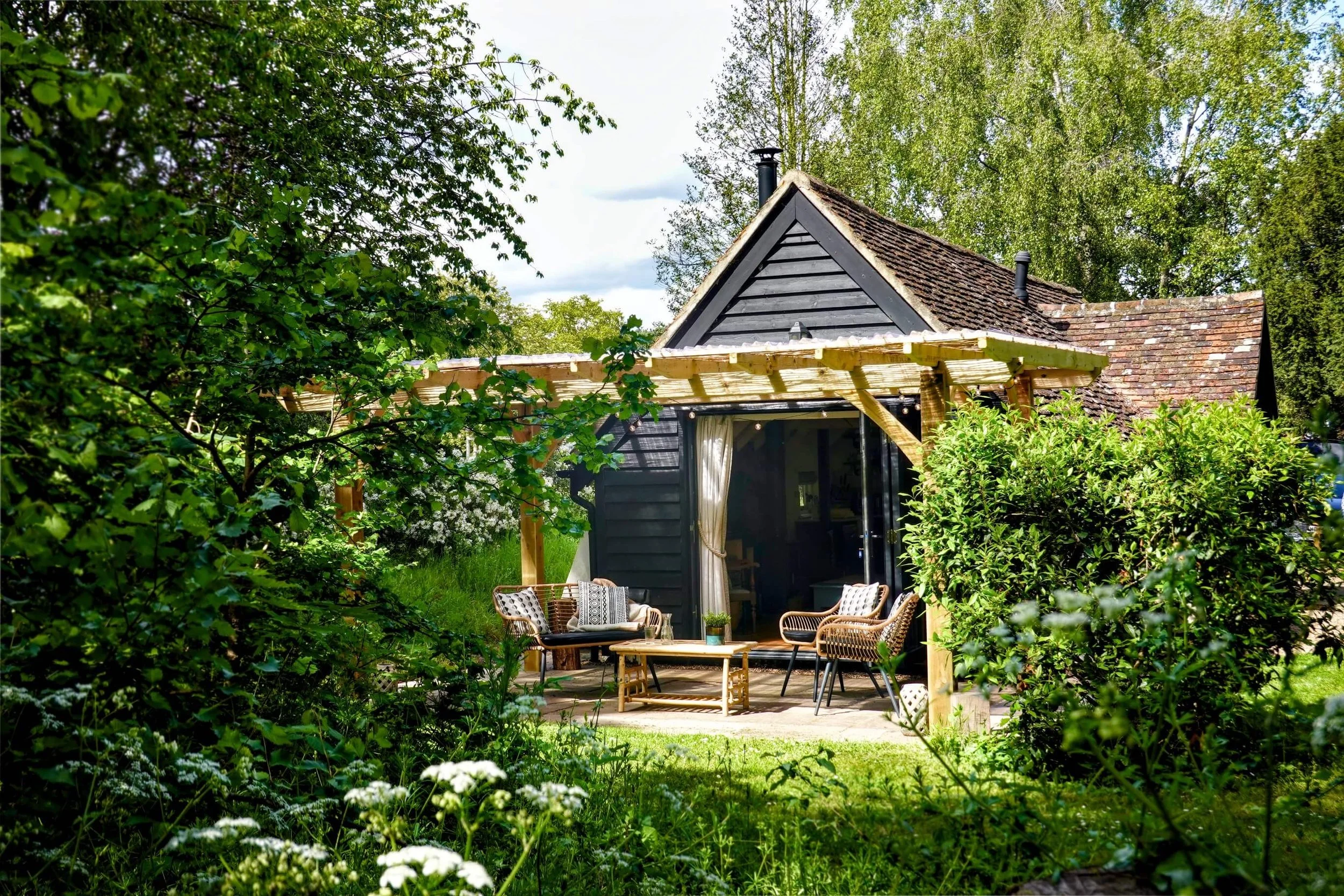 The Snuggery cottage surrounded by trees in the Kent countryside.