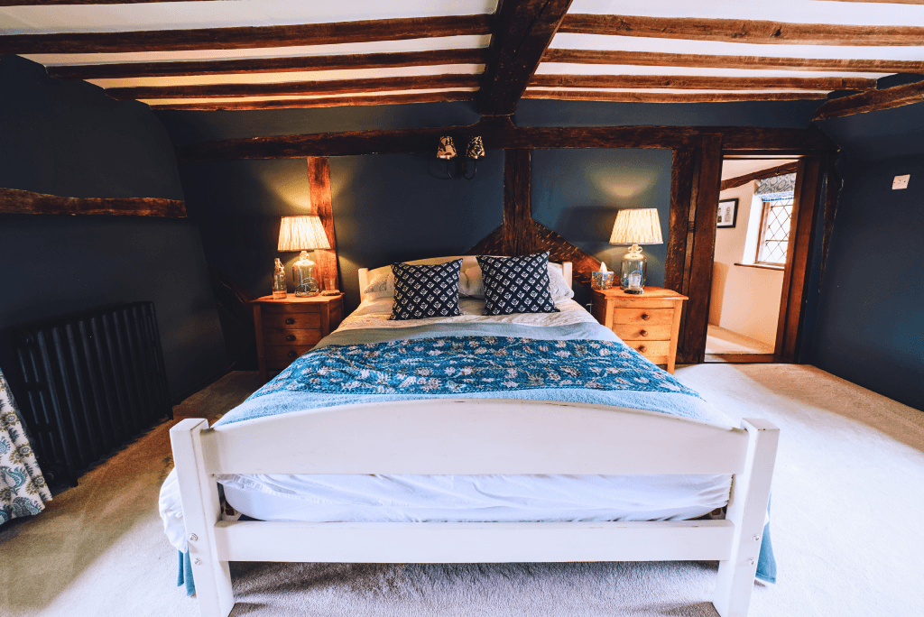 Rustic countryside bedroom with exposed beams.