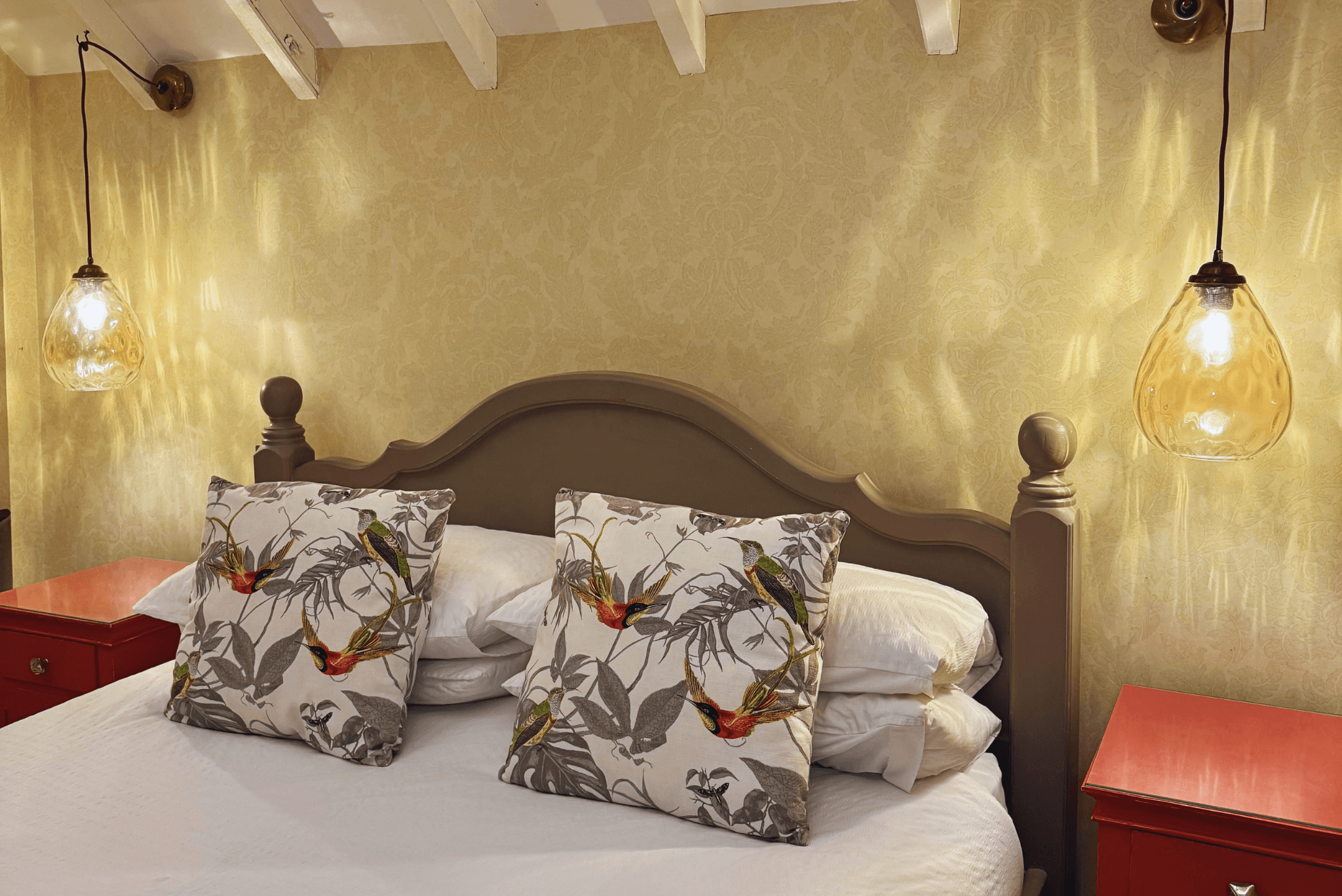 Cosy cottage bedroom with exposed beams and soft lighting.