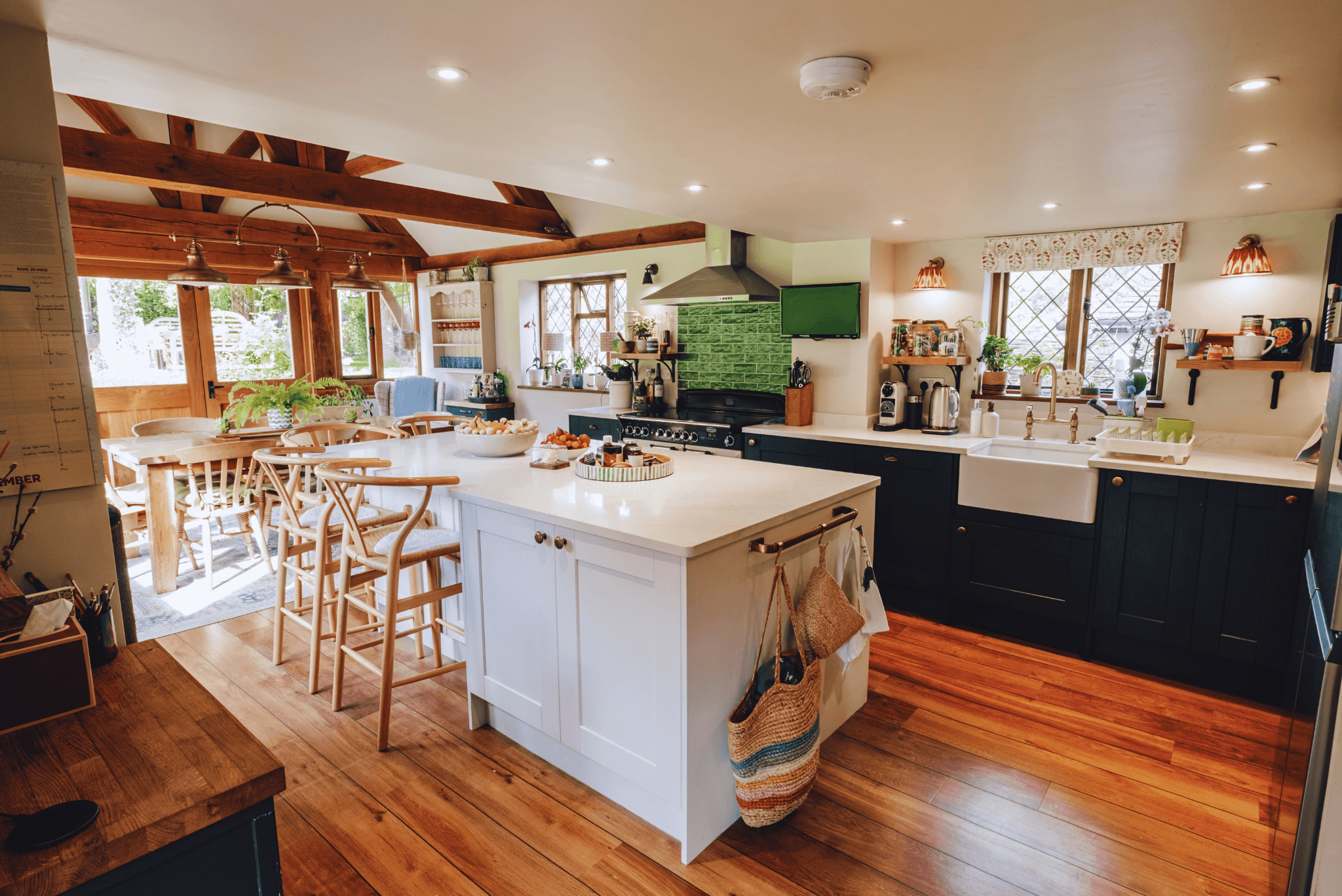 Rustic country kitchen at High Birch with exposed beams, green tiles and large farmhouse island.