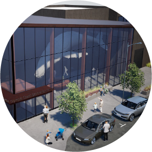 A modern building with large glass windows, people walking on the sidewalk, two cars parked, and trees along the street.