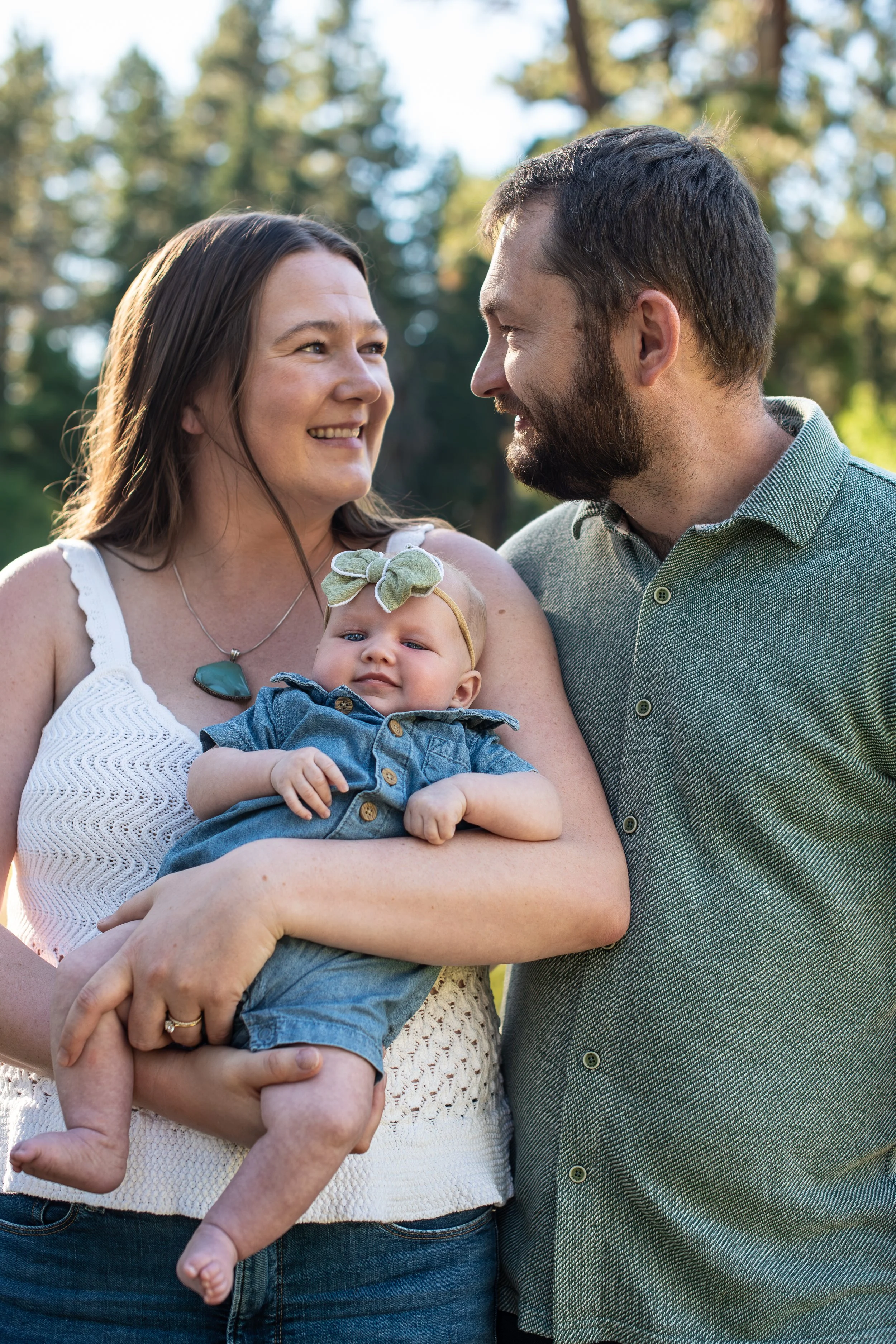 Mom and dad looking at each other holding the baby