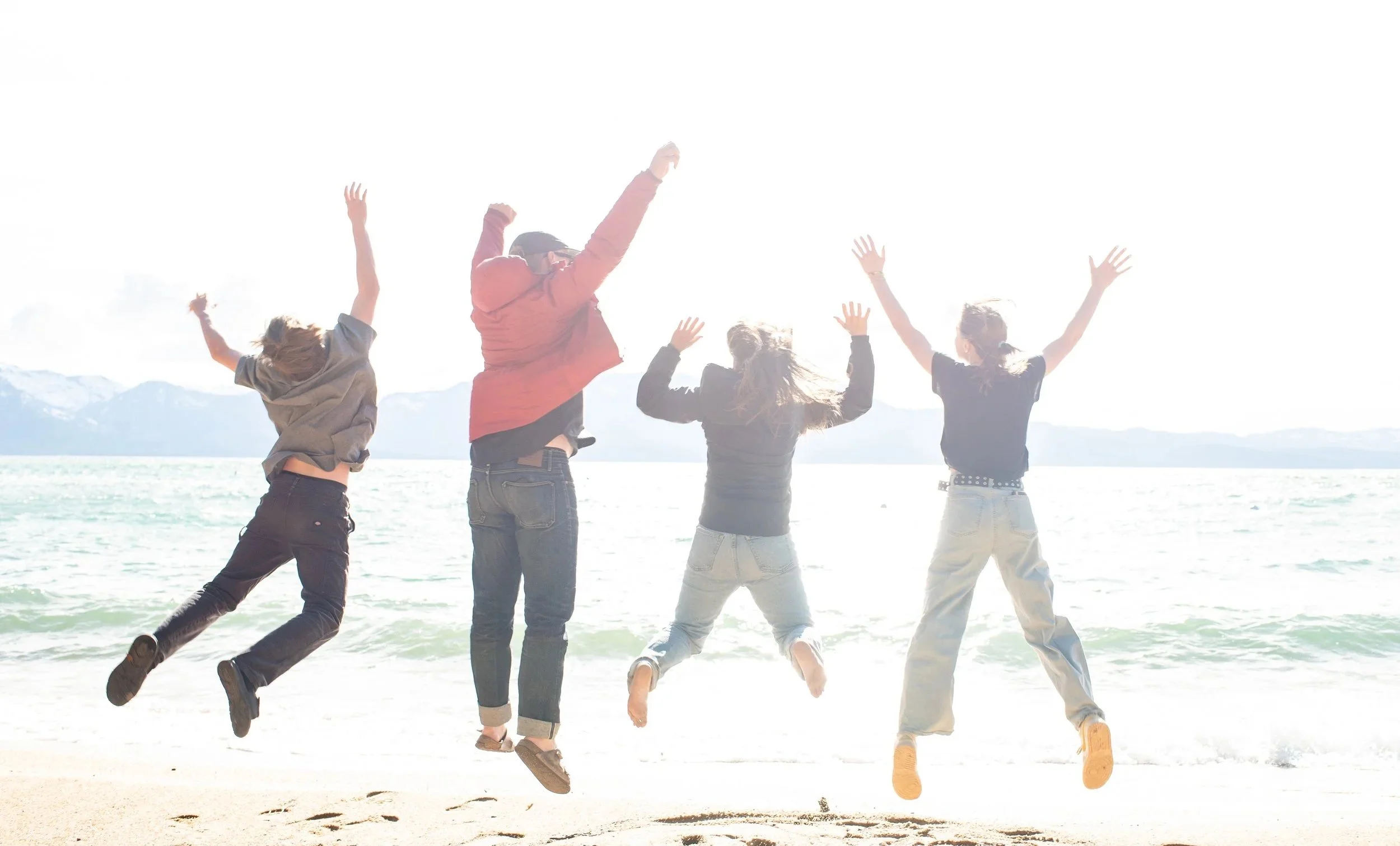 Family of four doing a jumping photo on the beach at Lake Tahoe