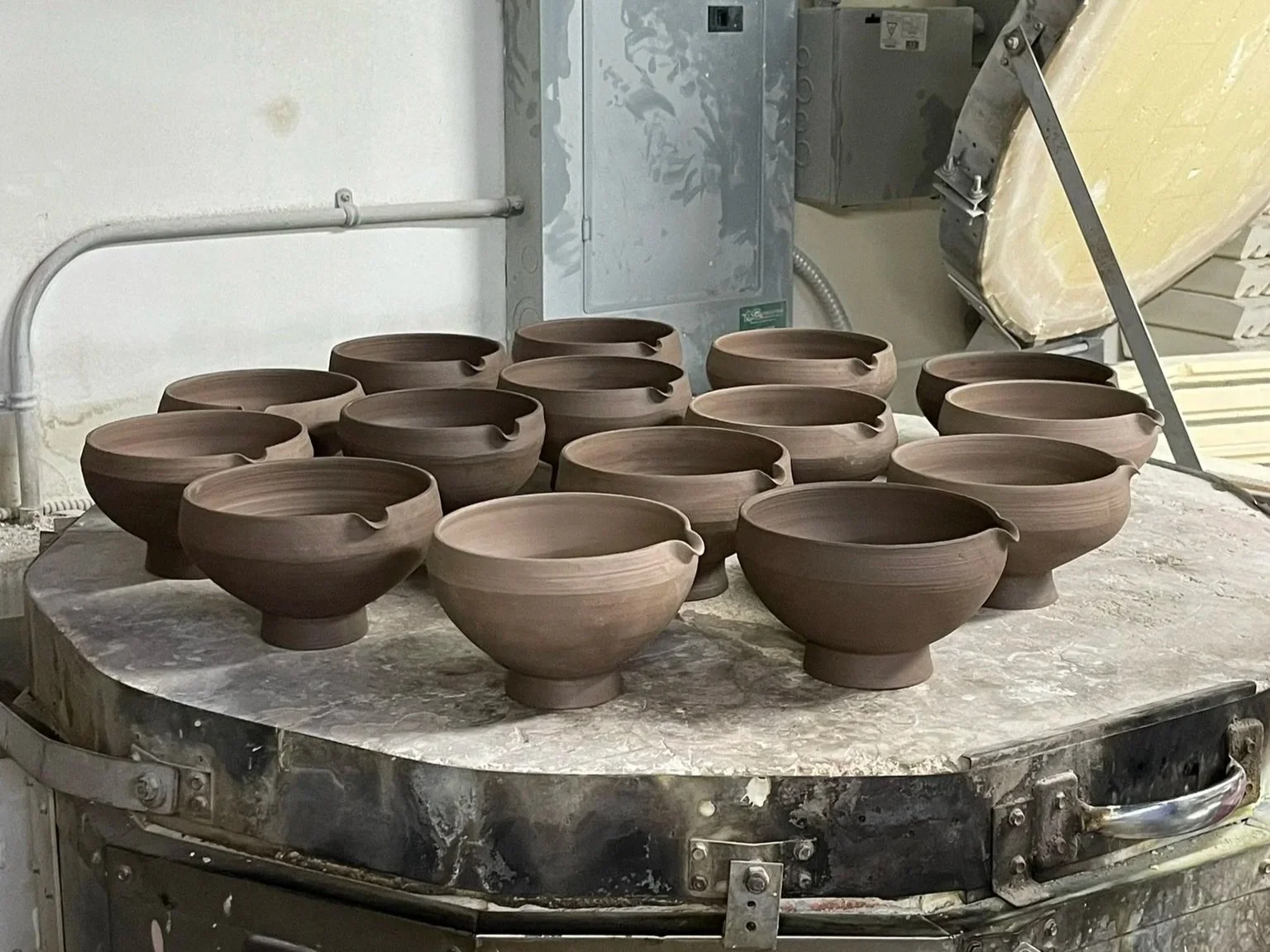 Clay bowls on a kiln in a pottery studio.