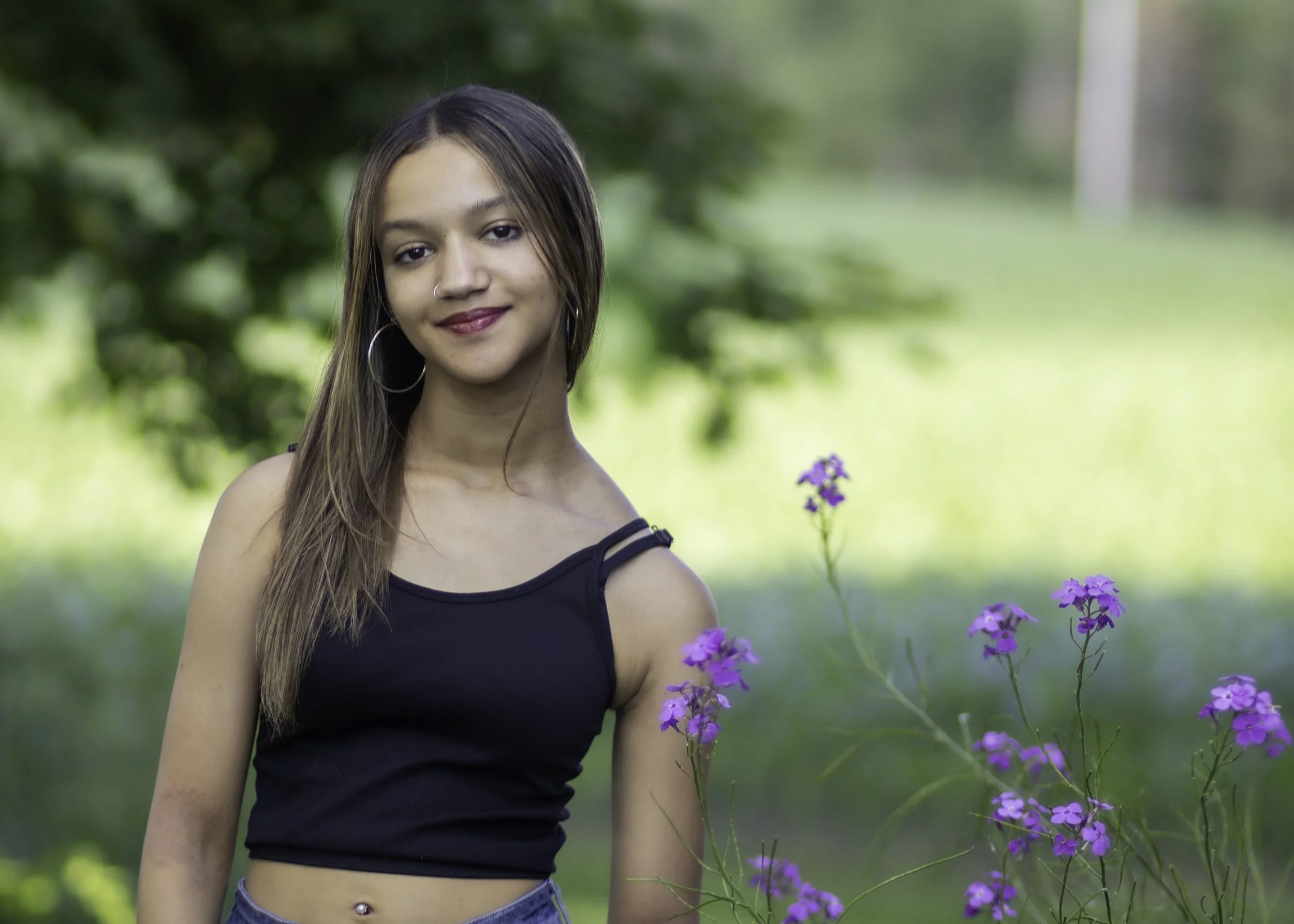 Senior session with young woman in front of flowers
