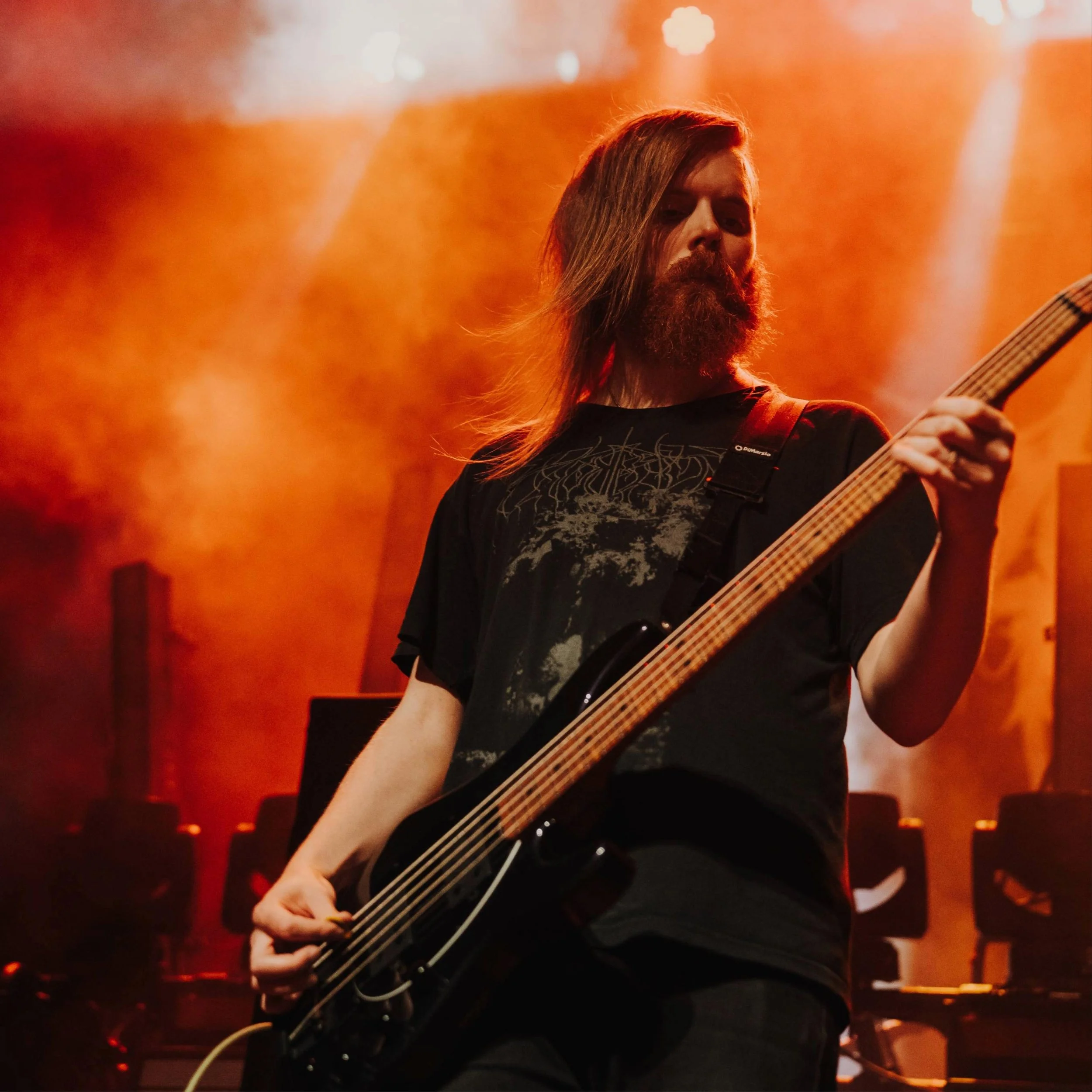 Cole on stage holding a bass guitar