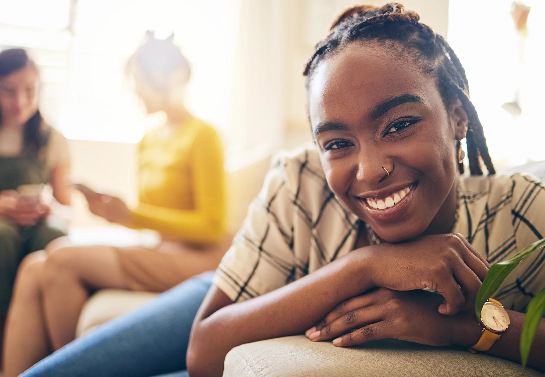 Young African American Woman facing camera and smiling with women in background