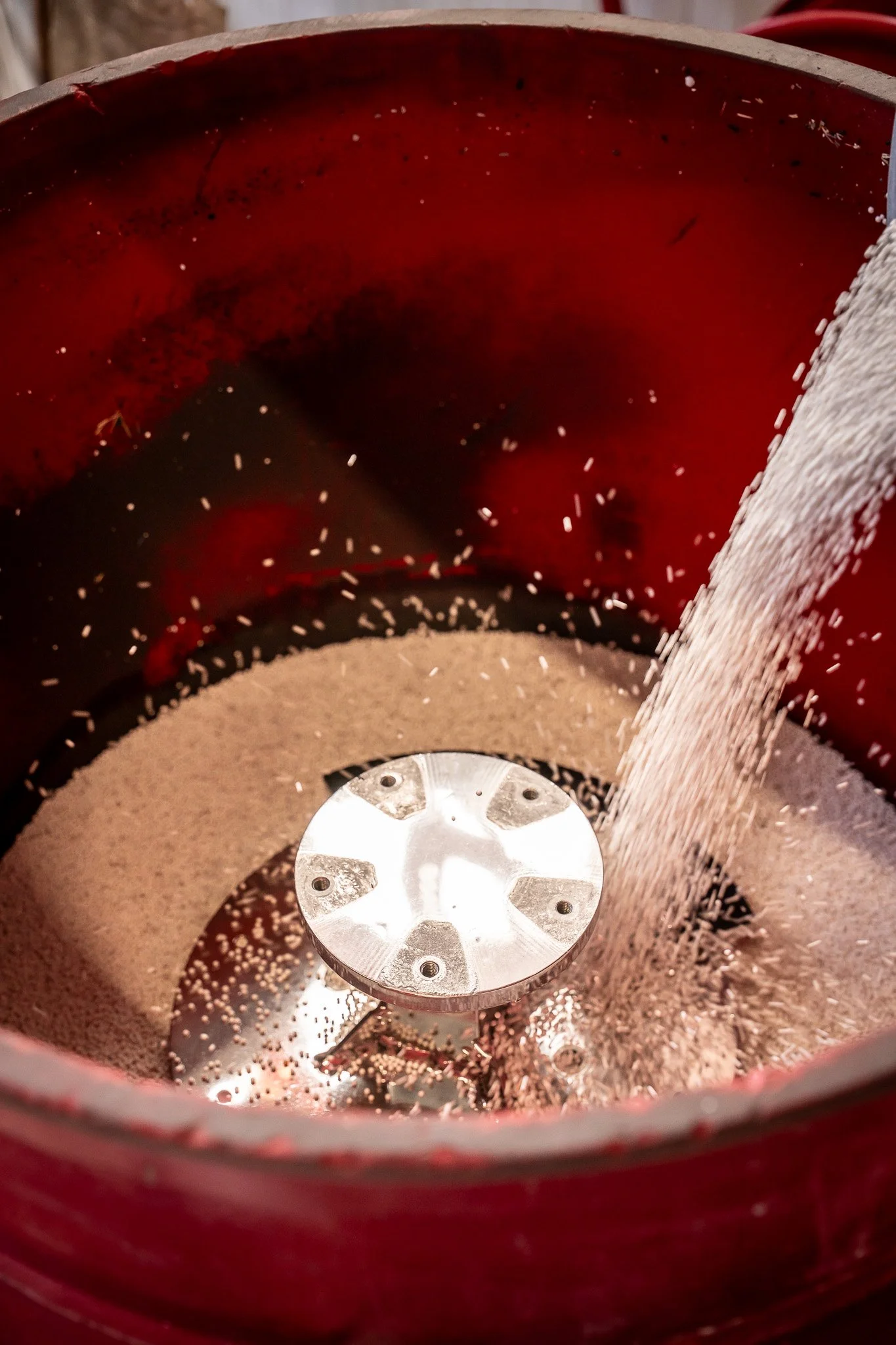 Close-up of a spice grinder with rice or similar grains being ground inside.