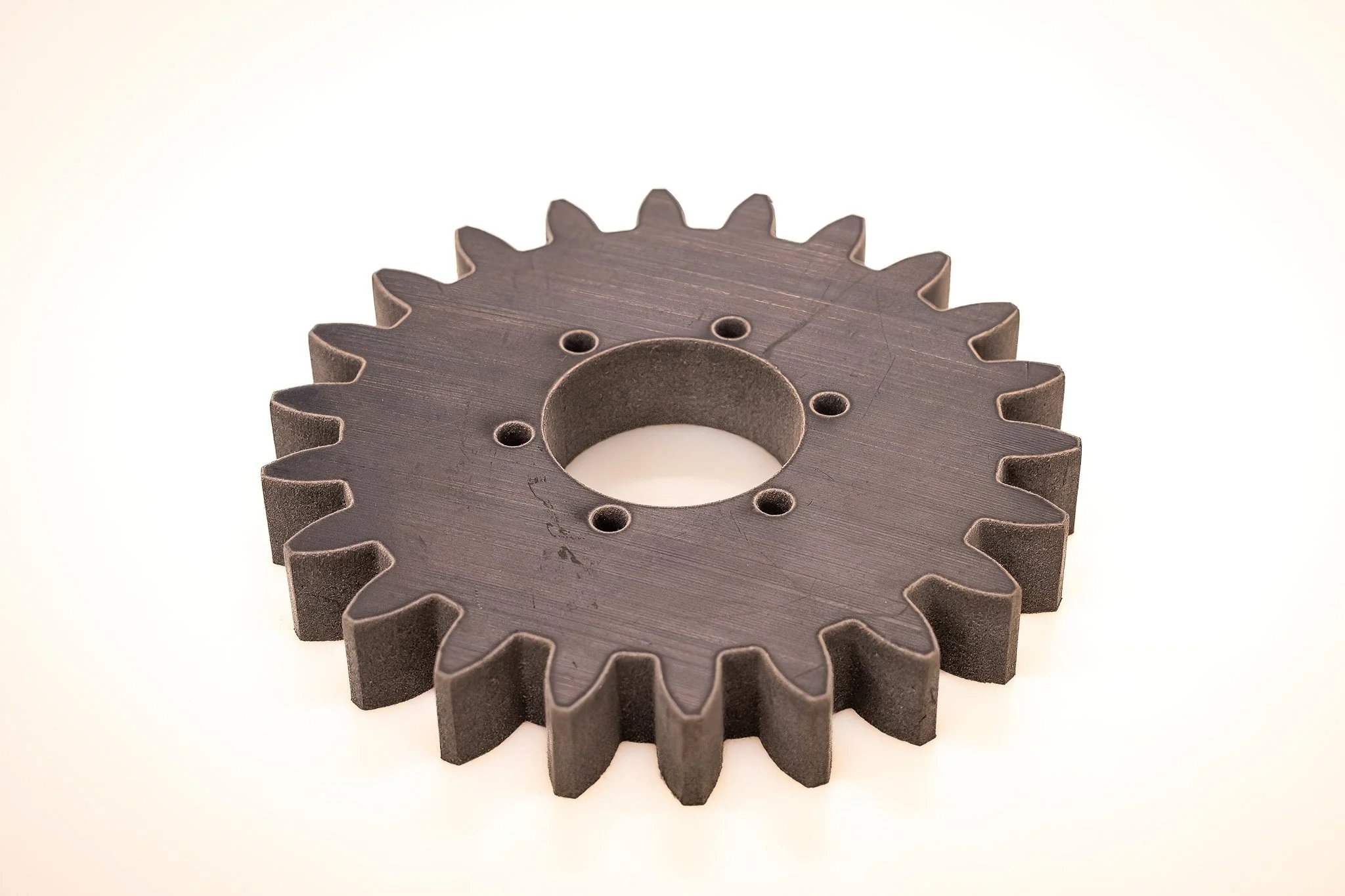 Two metal gears stacked together on a white surface.