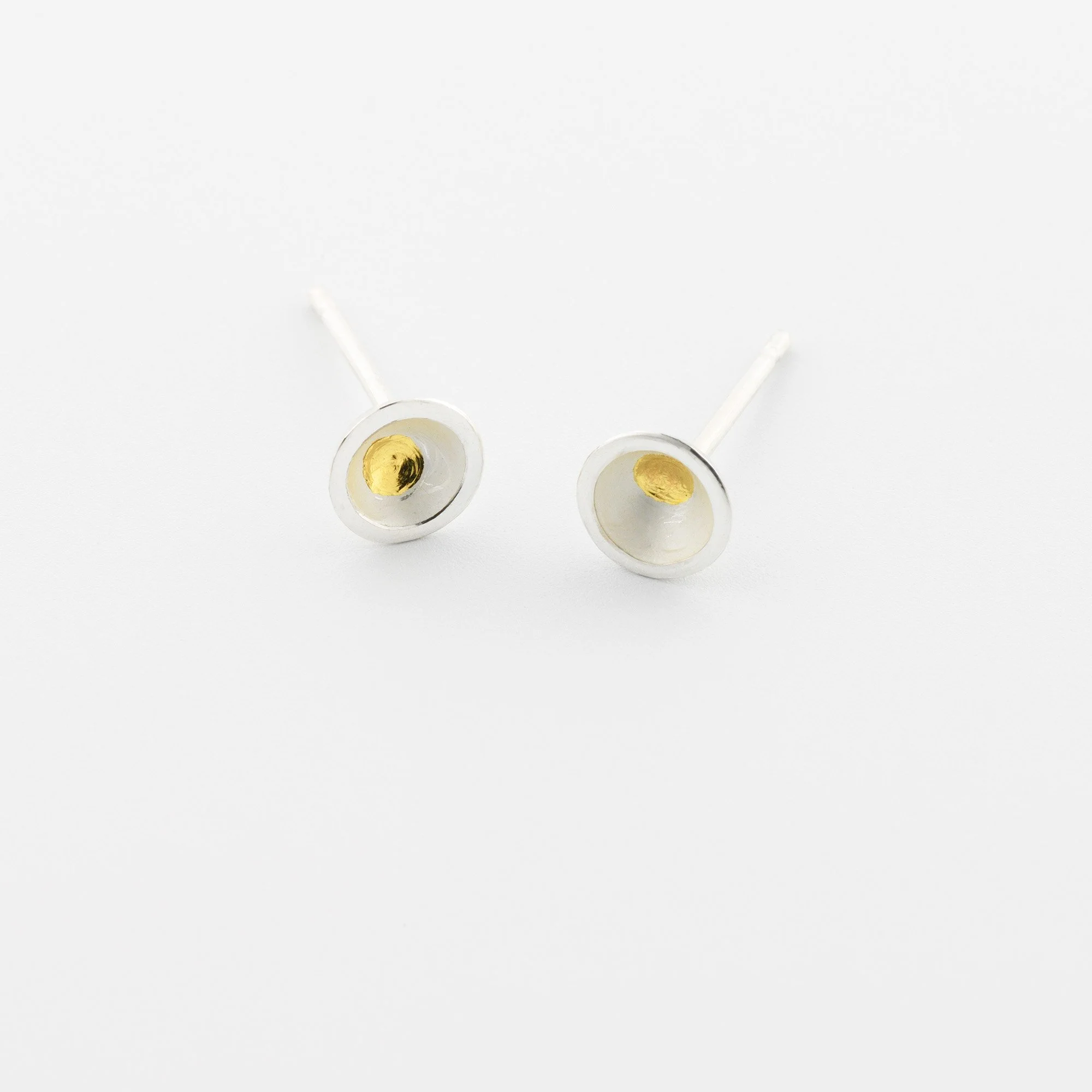 Tiny domed sterling silver stud earrings with a white interior, central gold keum boo dot and polished edges
