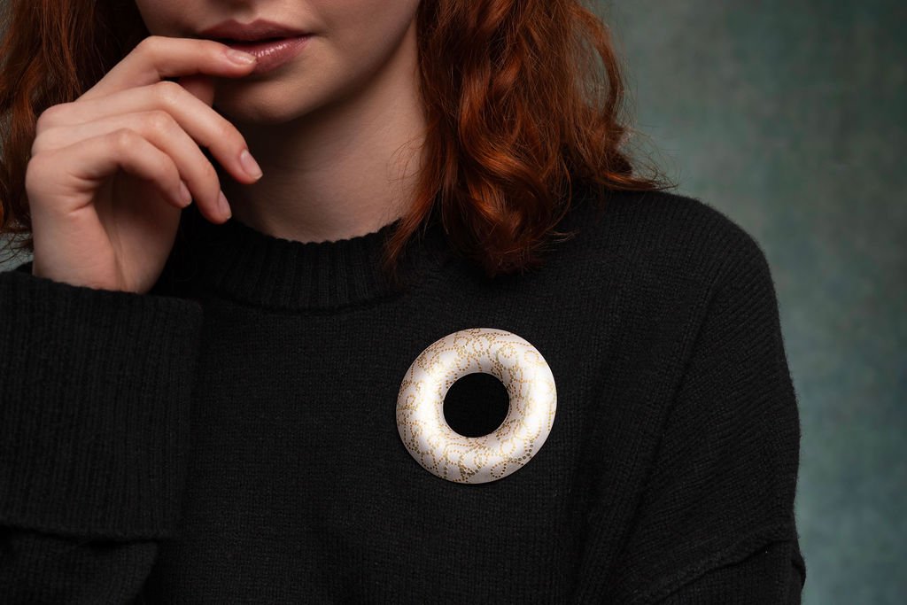 Model wearing sterling silver Interlace brooch with intricate 24ct gold keum boo pattern on black knit jumper.
