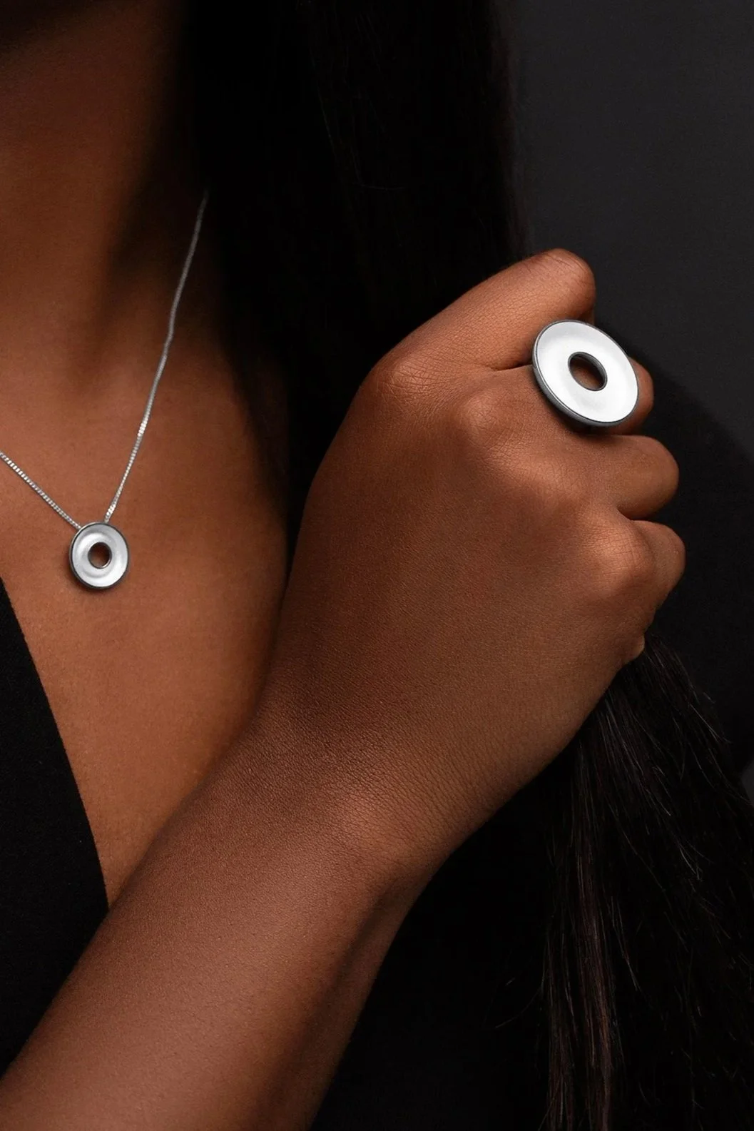 Hand wearing sterling silver Orbis large ring, concave torus form, contrasting interior