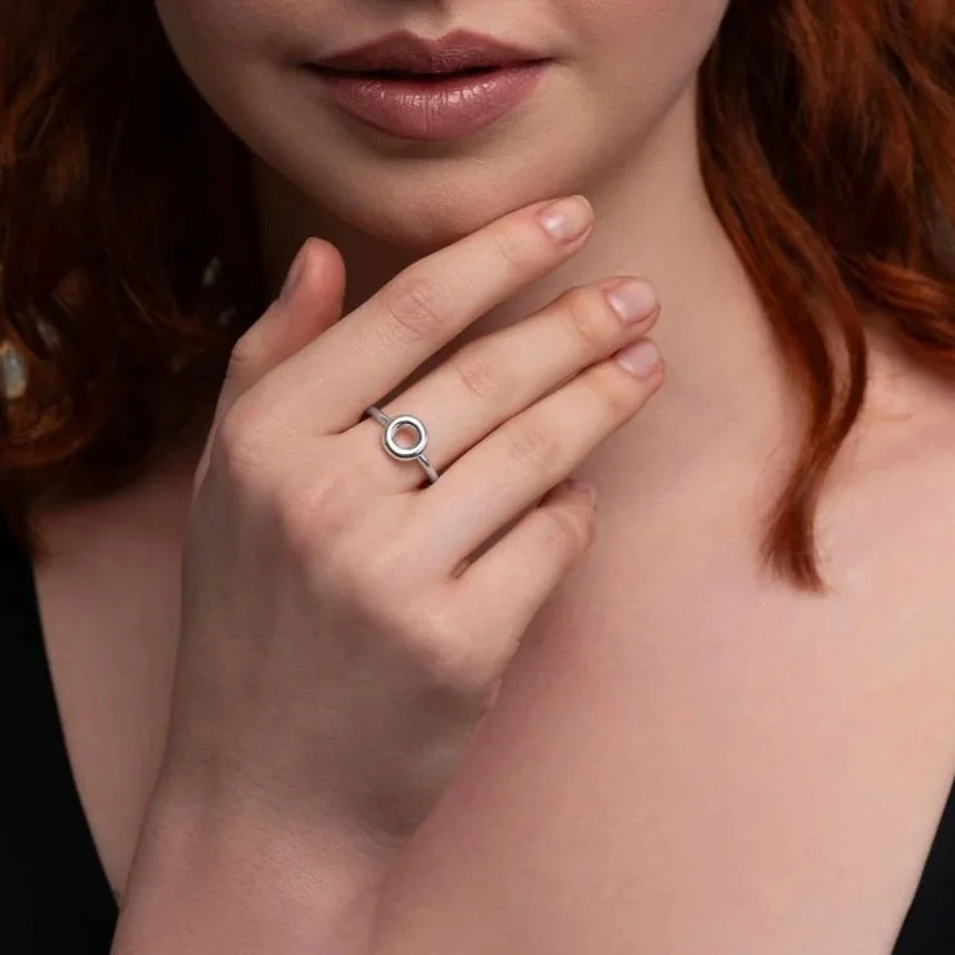 Close-up of hand wearing Monad ring, polished torus form in sterling silver