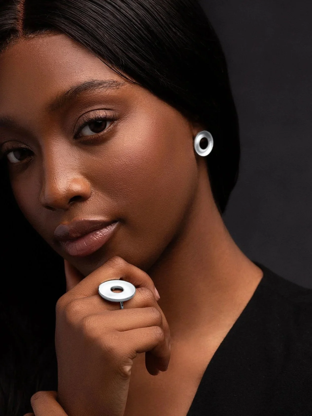 Model wearing sterling silver Orbis medium stud earrings, concave torus form