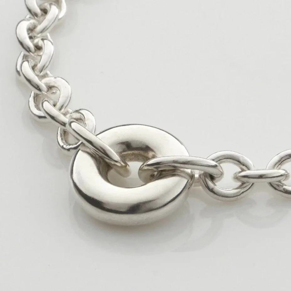 Close-up of Monad chain bracelet showing hollow torus link in sterling silver